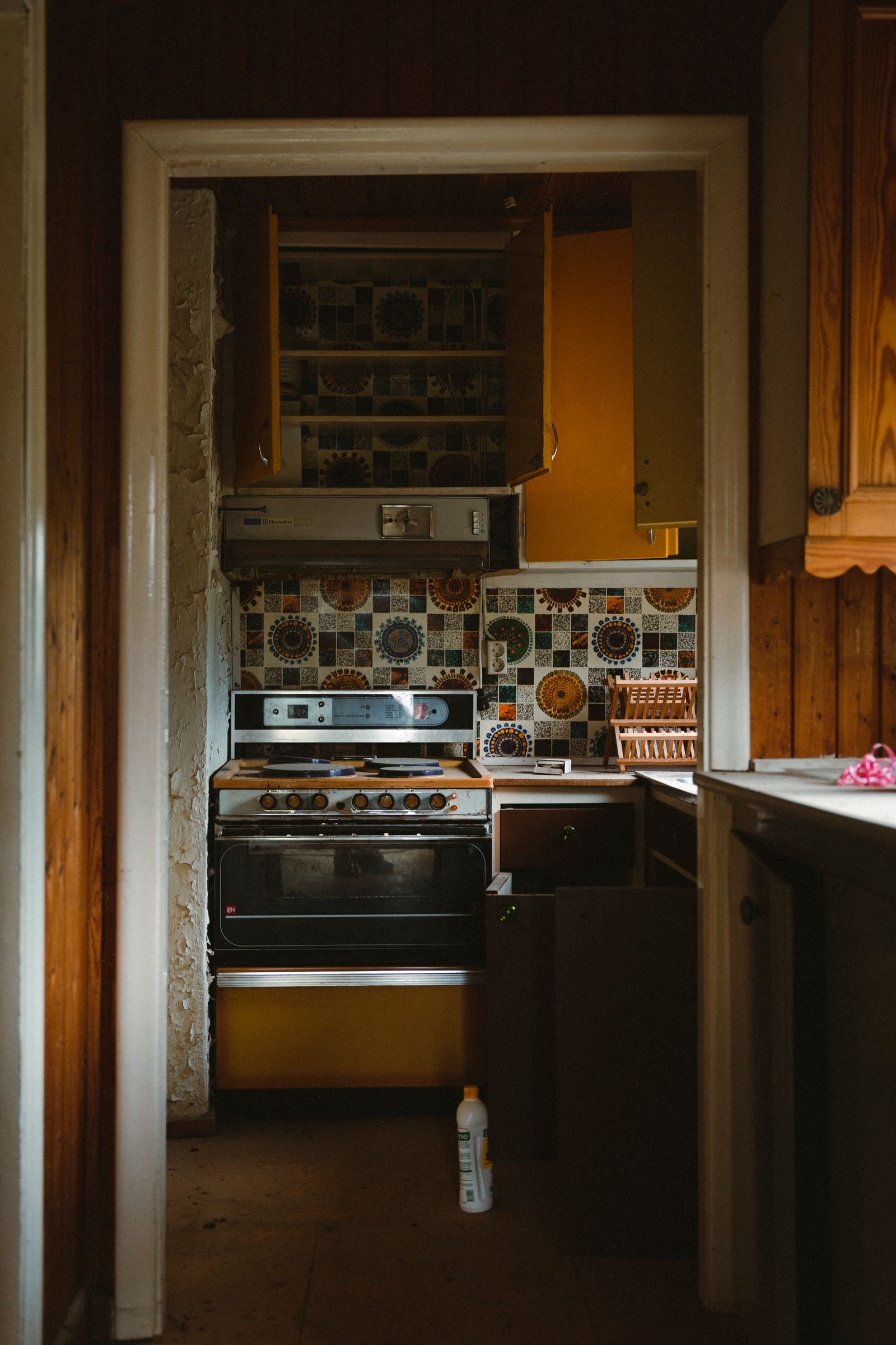 Retro kitchen with vintage tiles, a stove and yellow cabinets.