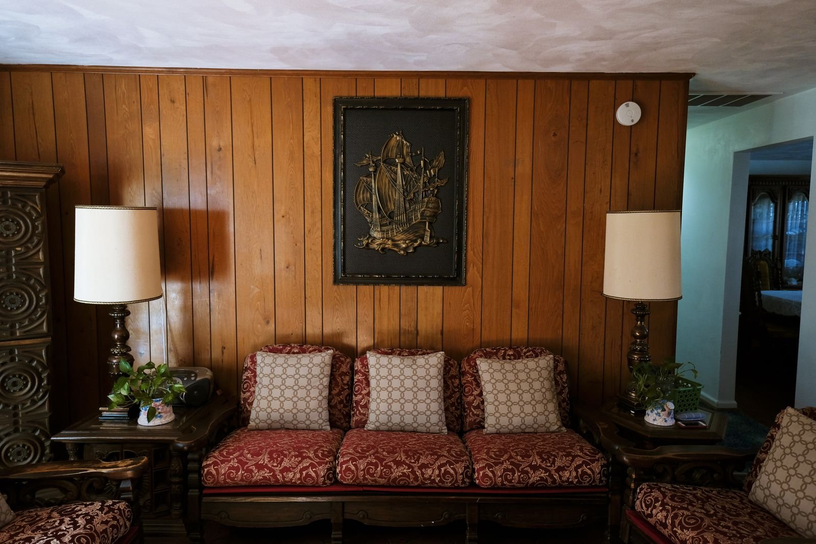 Warm living room with vintage furniture and wood paneling.