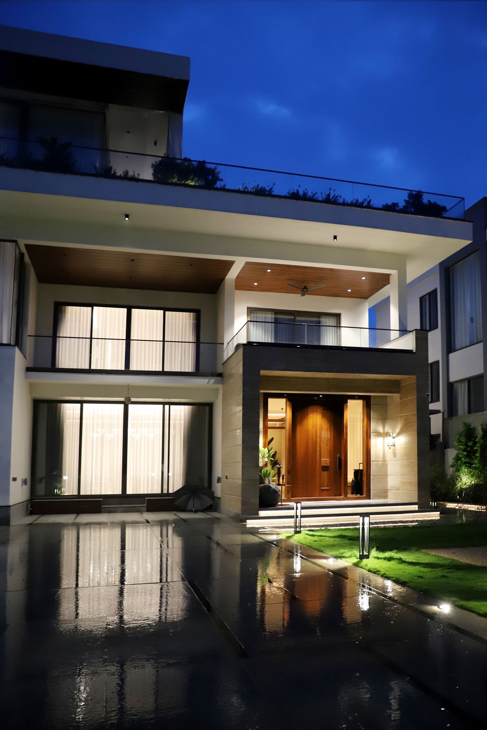 Modern luxury house glowing with warm exterior lights against the night sky