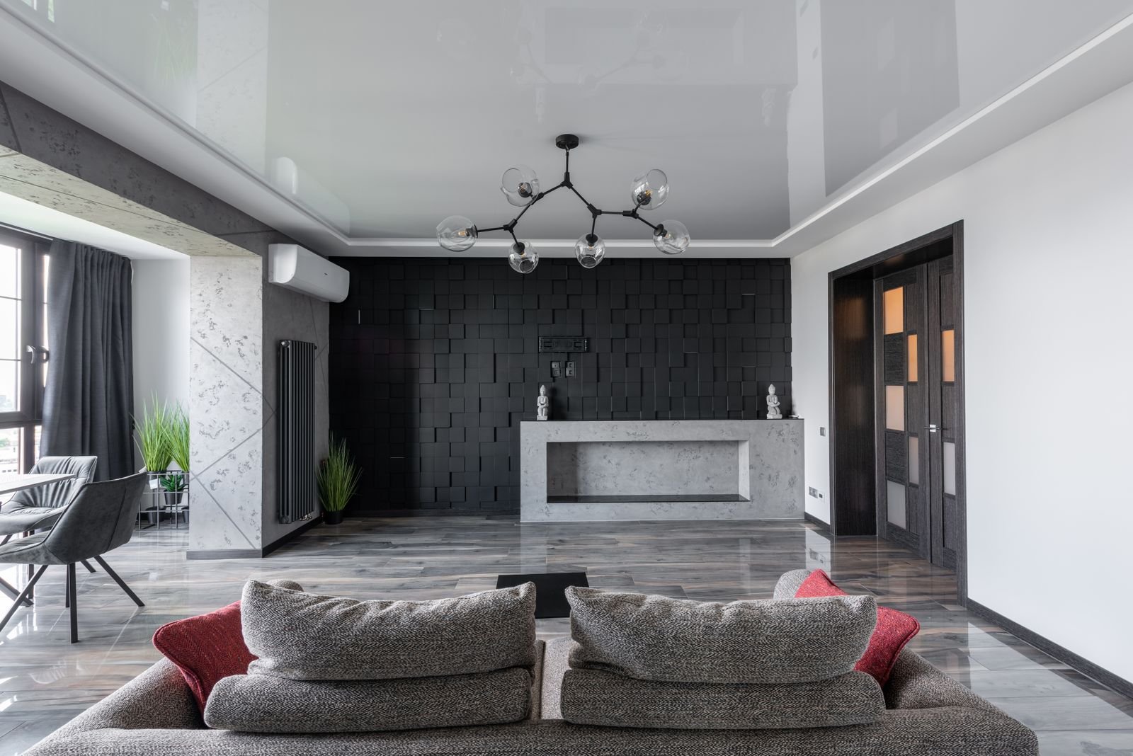 Living room with a bold black accent wall set against light furniture