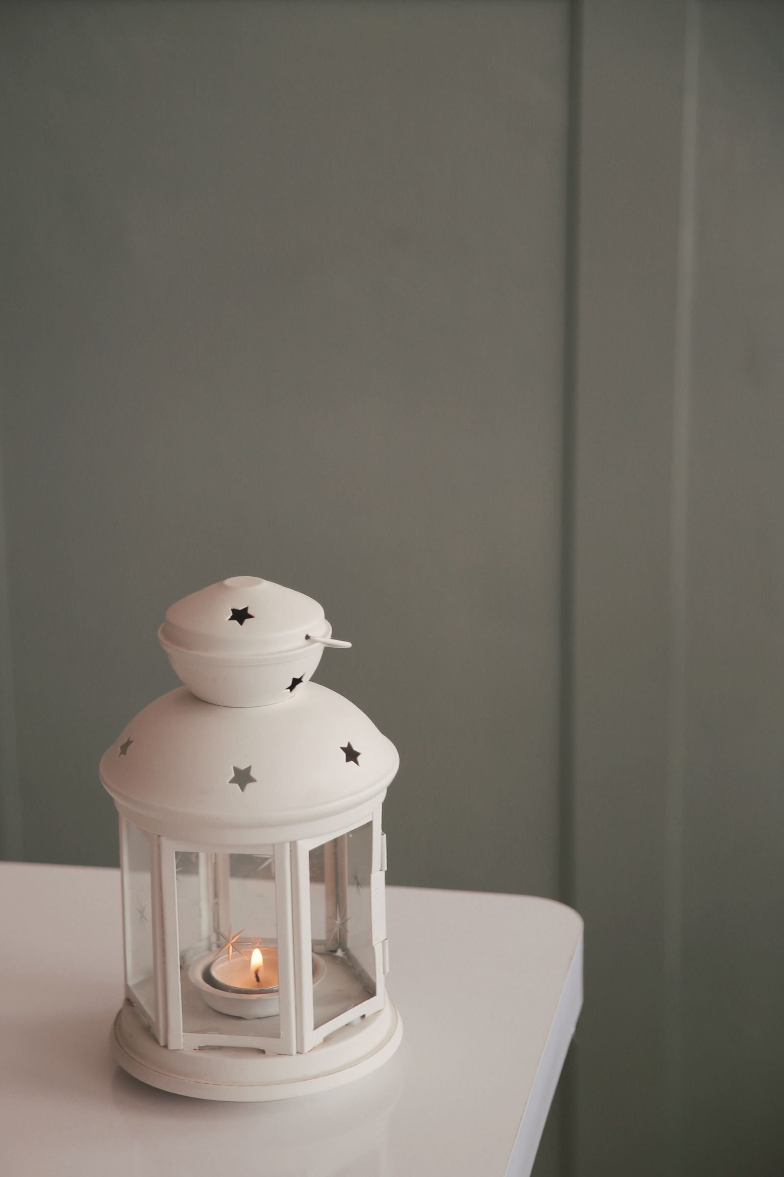 White lantern with a glowing candle adding a warm, cozy light indoors