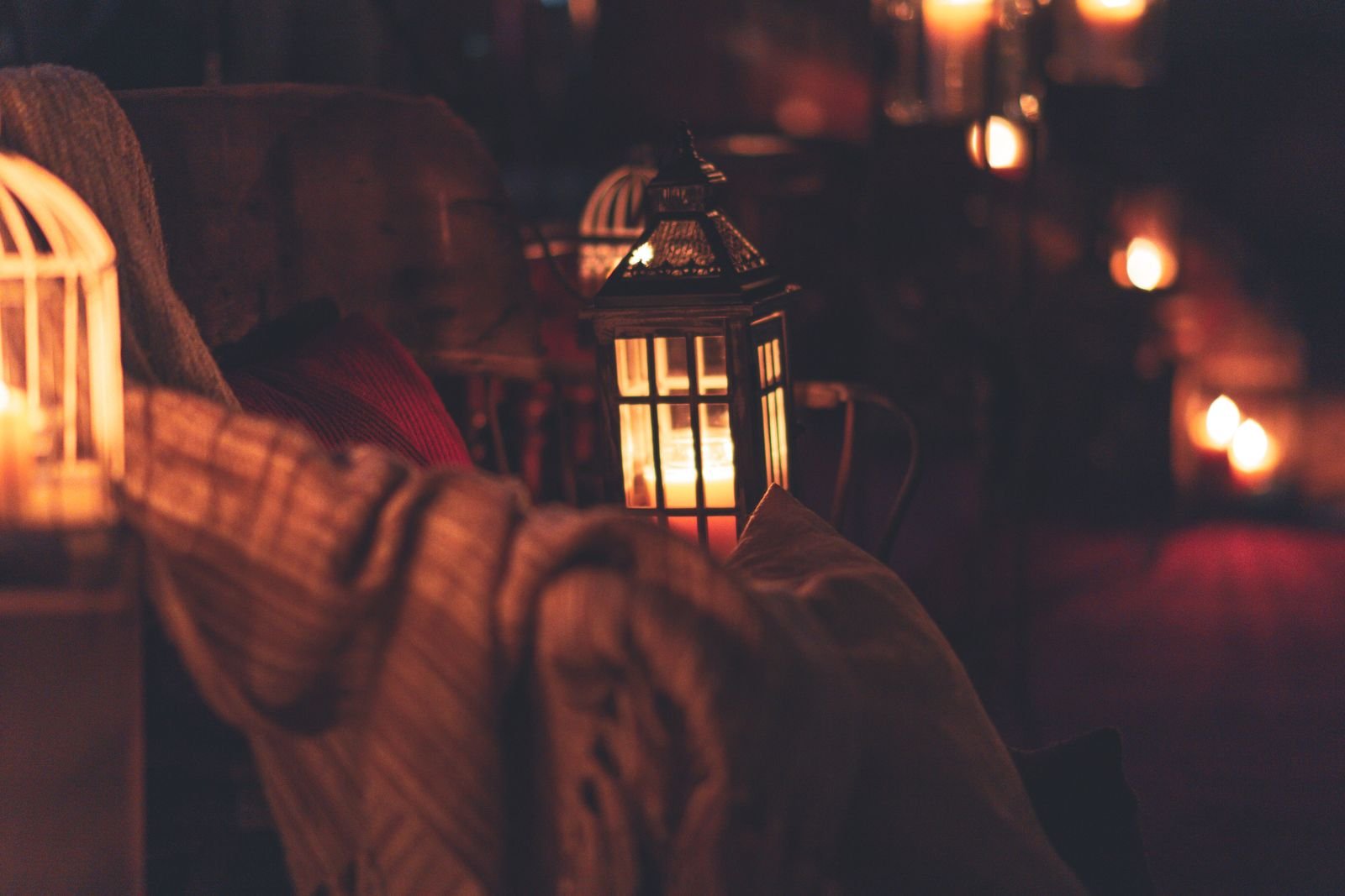 Candlelit lanterns beside soft textiles for a cozy look in any season