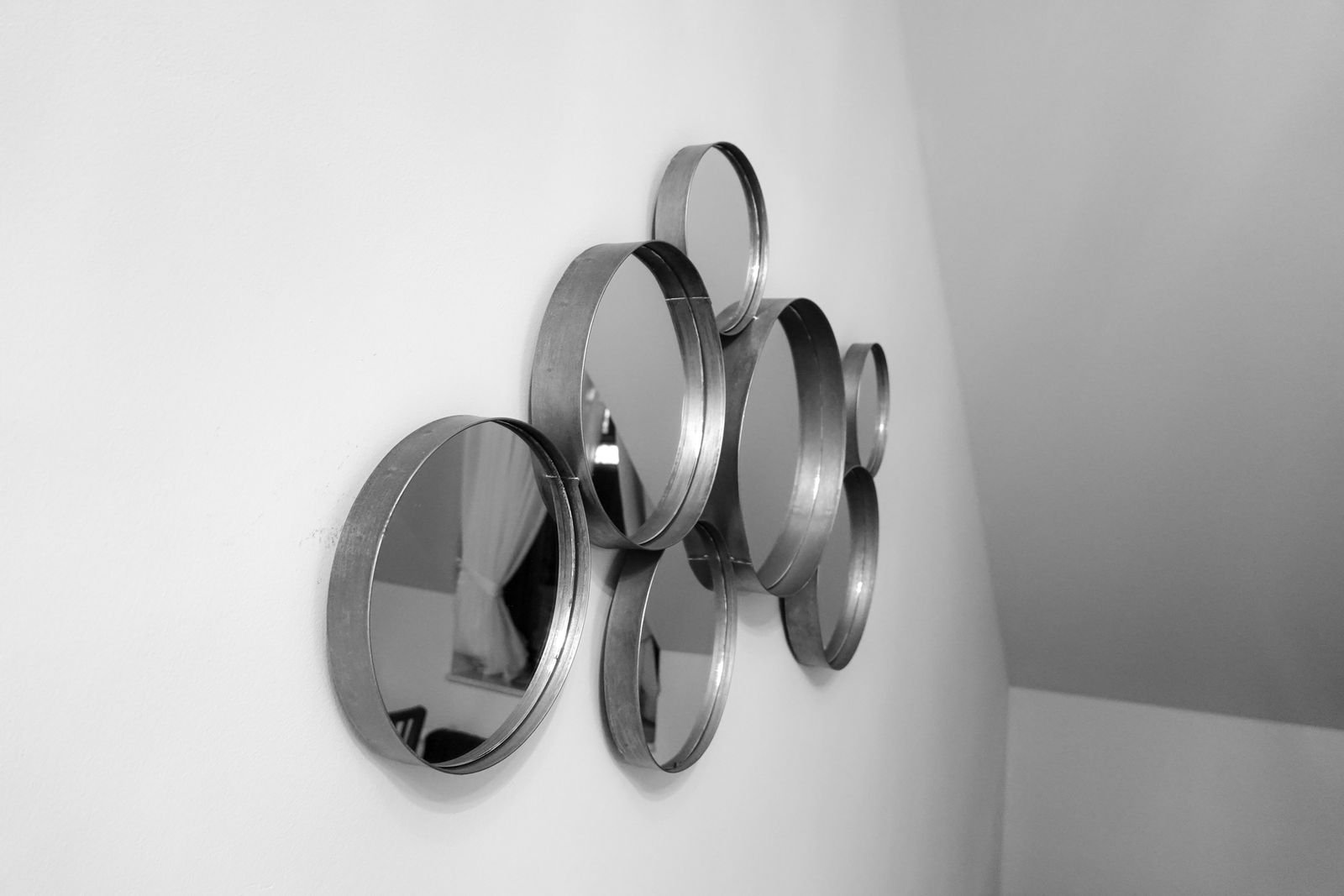Cluster of round mirrors in different sizes on a white wall