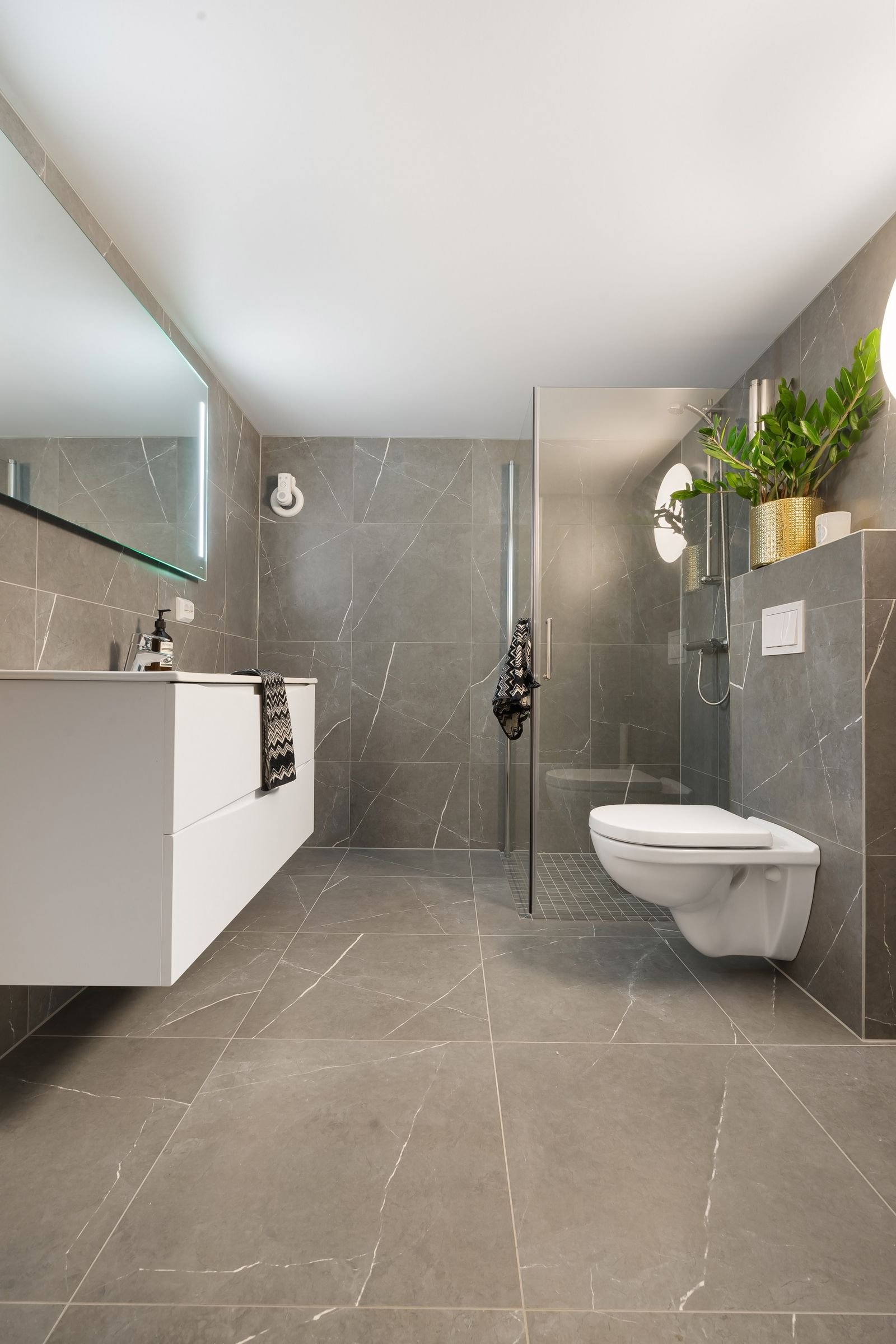 Gray tiled bathroom with matching wall and floor tile