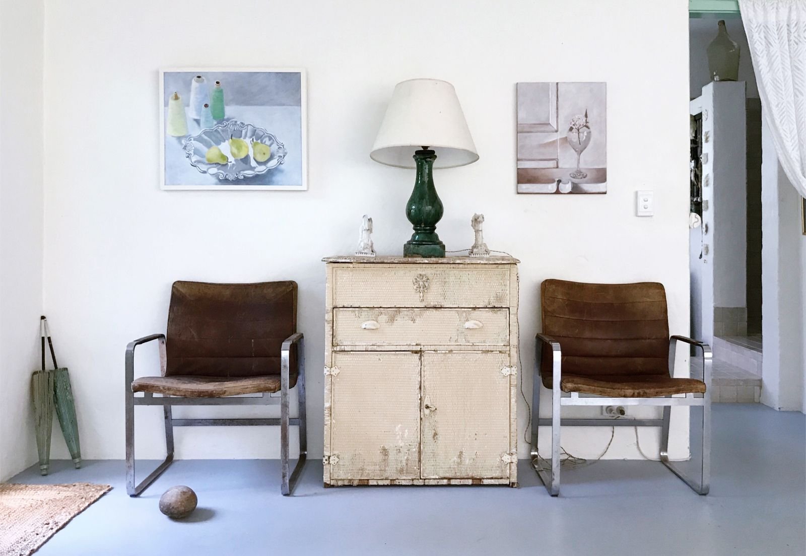Vintage chairs and a distressed cabinet with framed art prints