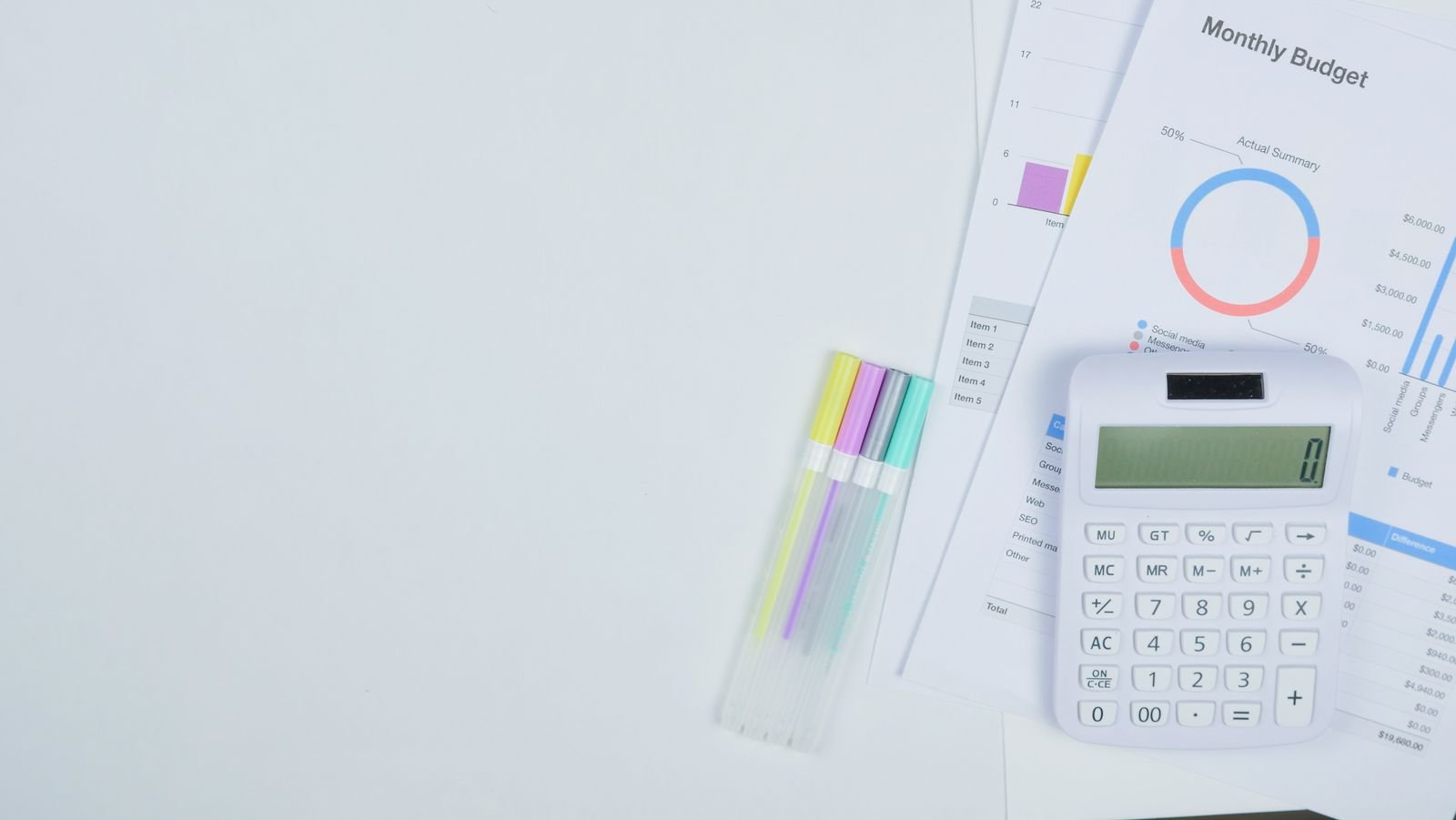 Desk with a calculator, documents and pens for planning a home decorating budget