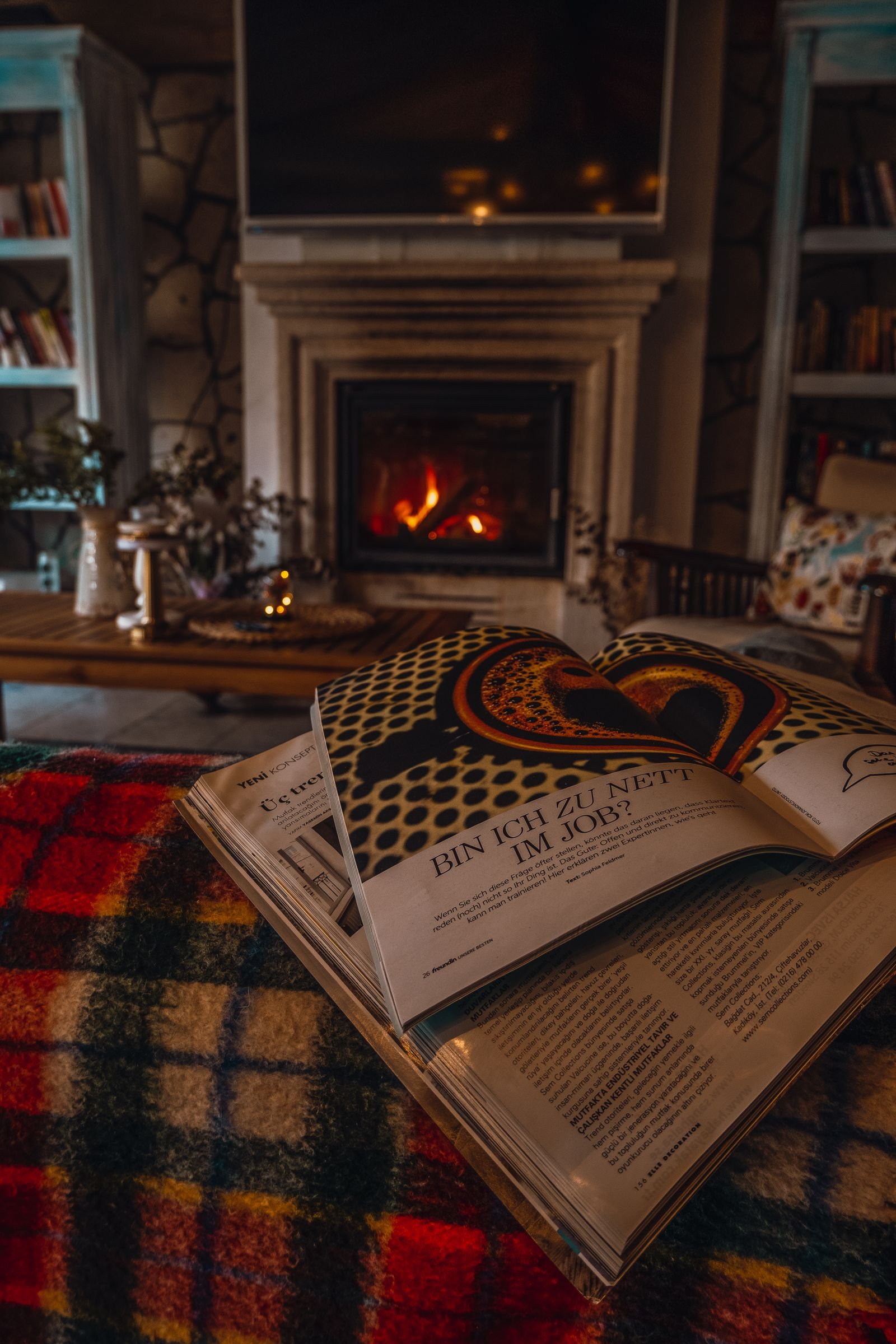 Cozy living room with a fireplace and a plaid blanket on the sofa