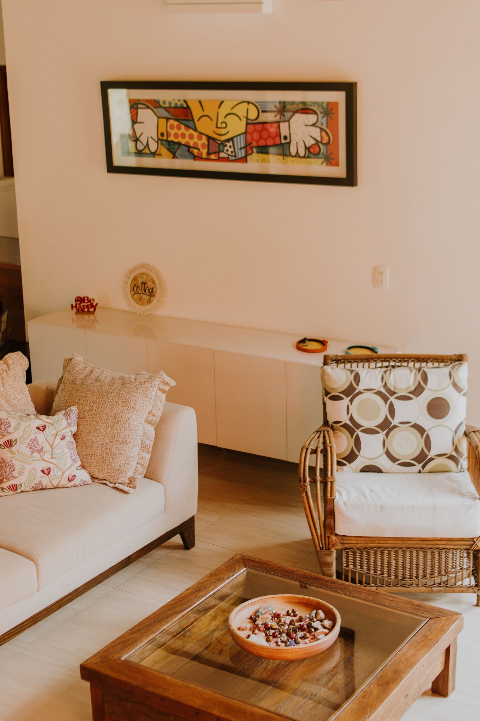 Living room with modern wall art, a rattan chair and a sofa
