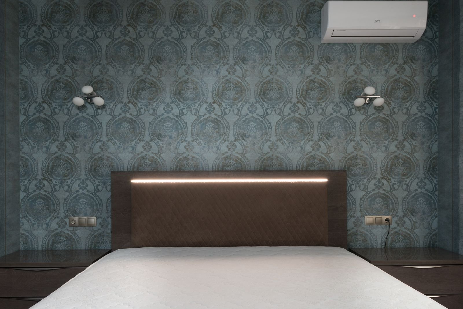 Bedroom with white wall sconces beside a bed with a brown headboard