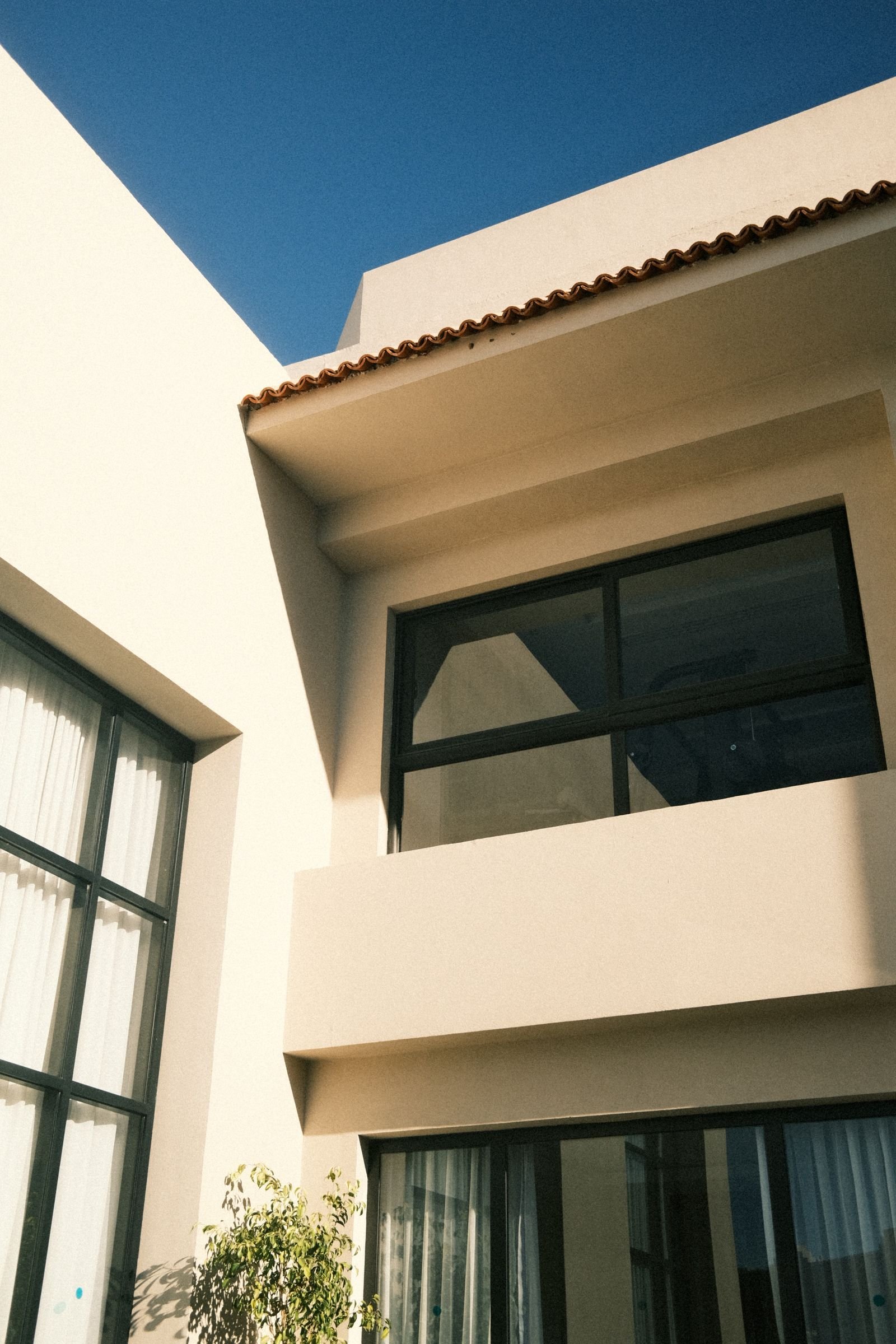 Modern house exterior with large windows under a clear blue sky