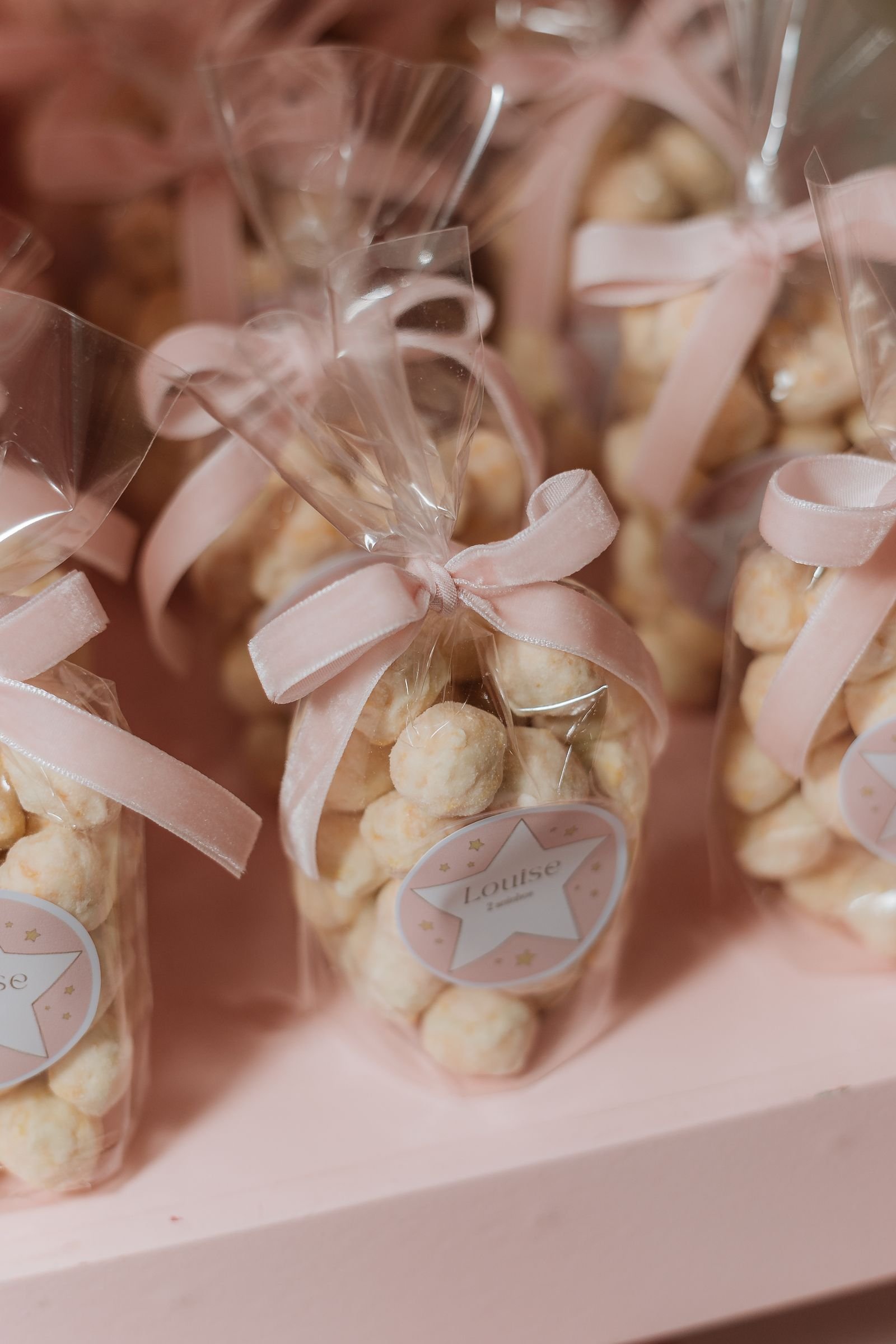 Birthday party favors wrapped in cellophane and tied with pink ribbons