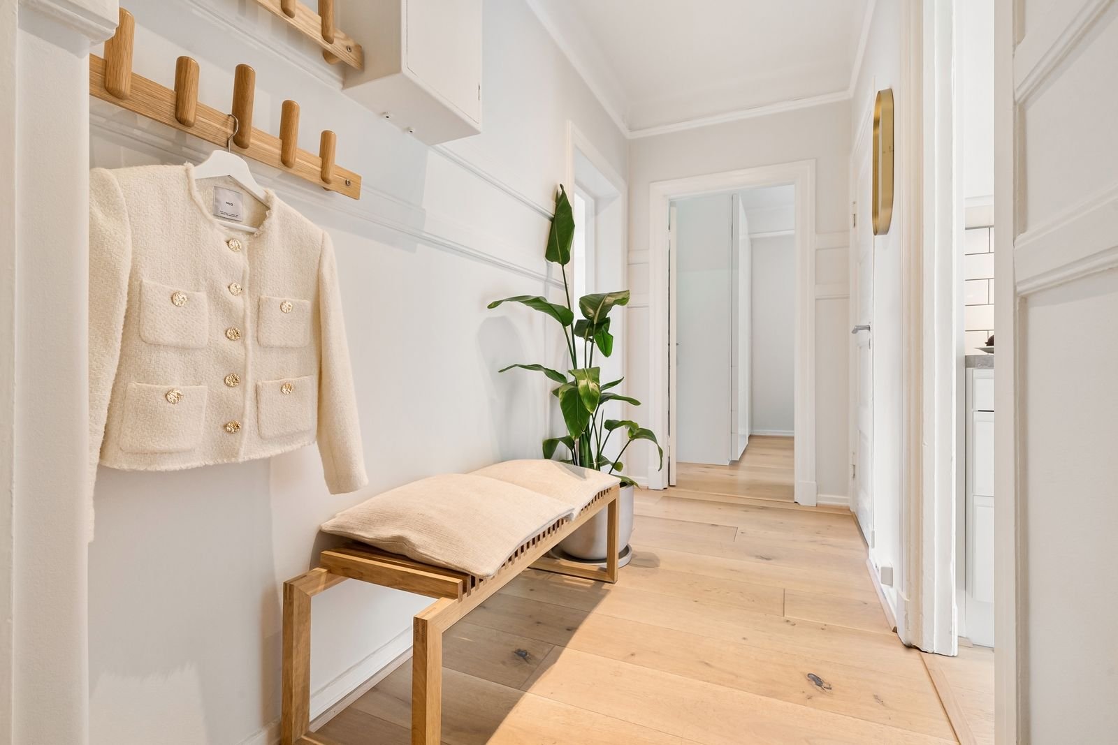 Tidy entry hallway with wooden furniture and a coat rack