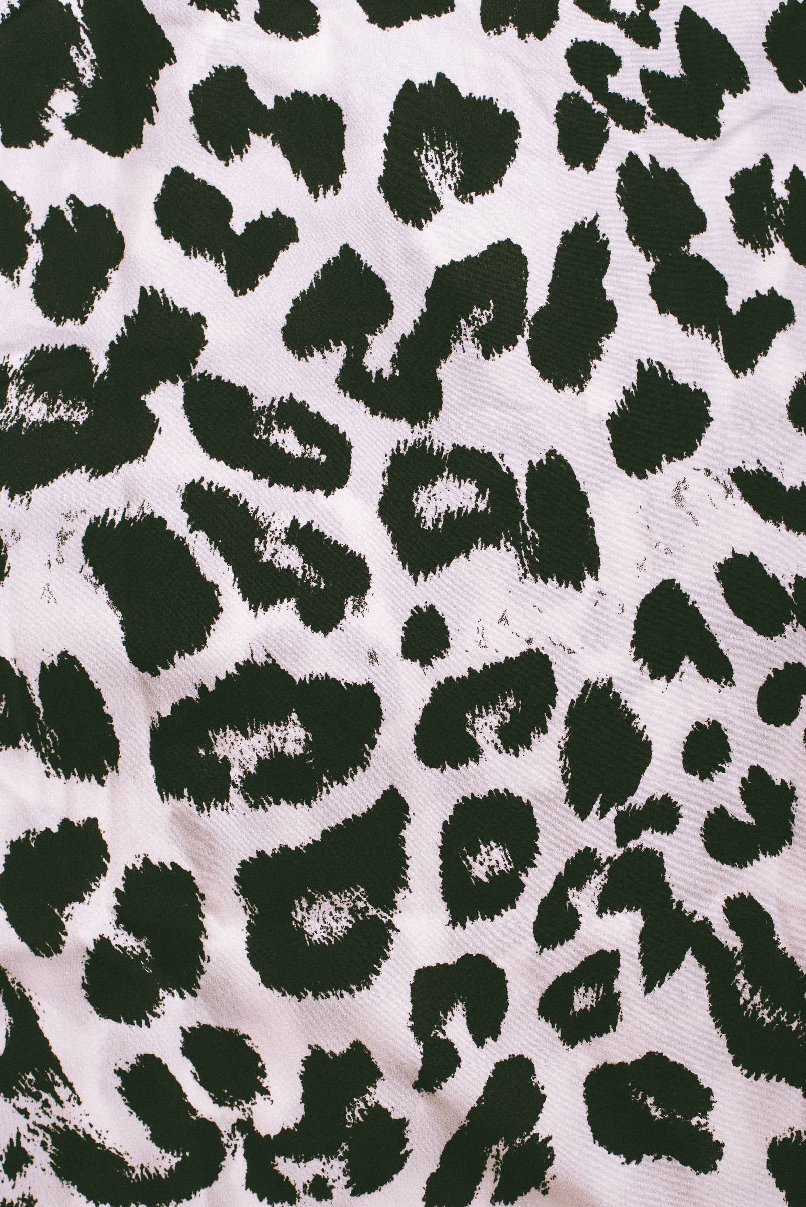 Close-up of leopard print on a soft, smooth fabric.