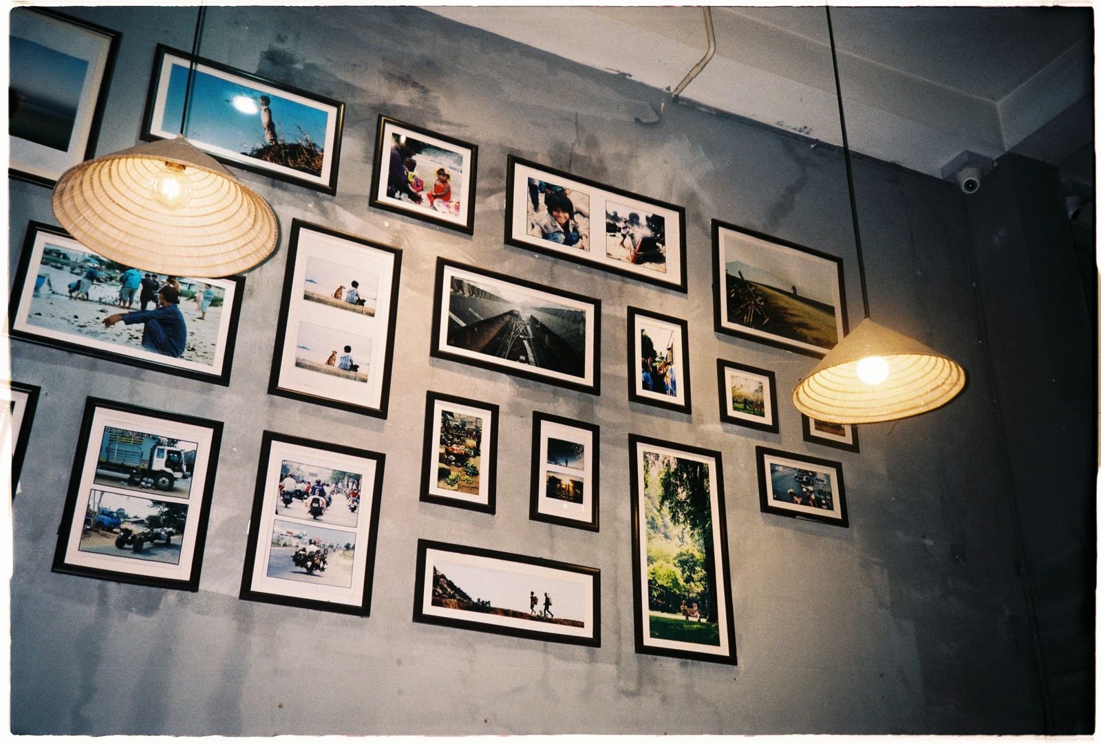 Framed photos arranged on a gray wall in a cozy room.