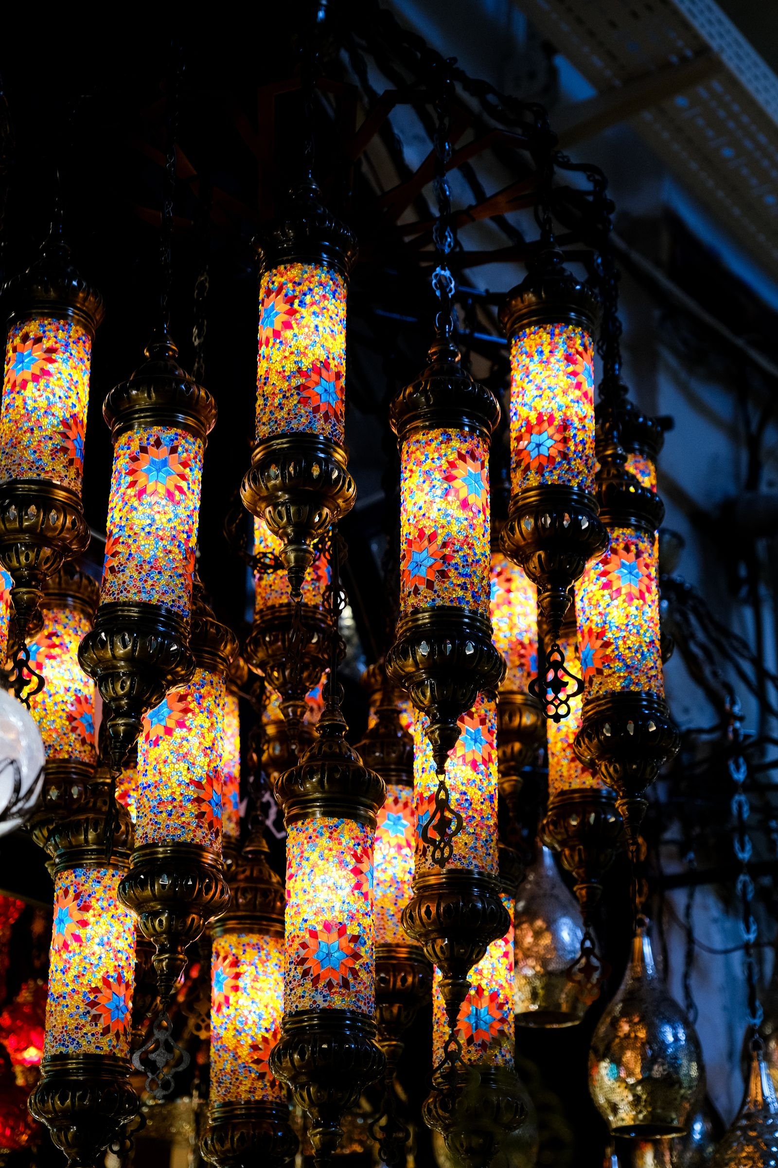 Mosaic lanterns hanging indoors in a warm, inviting glow.
