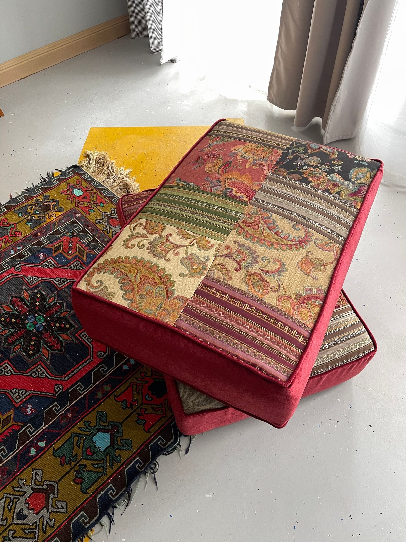 Patchwork cushions on a patterned carpet.