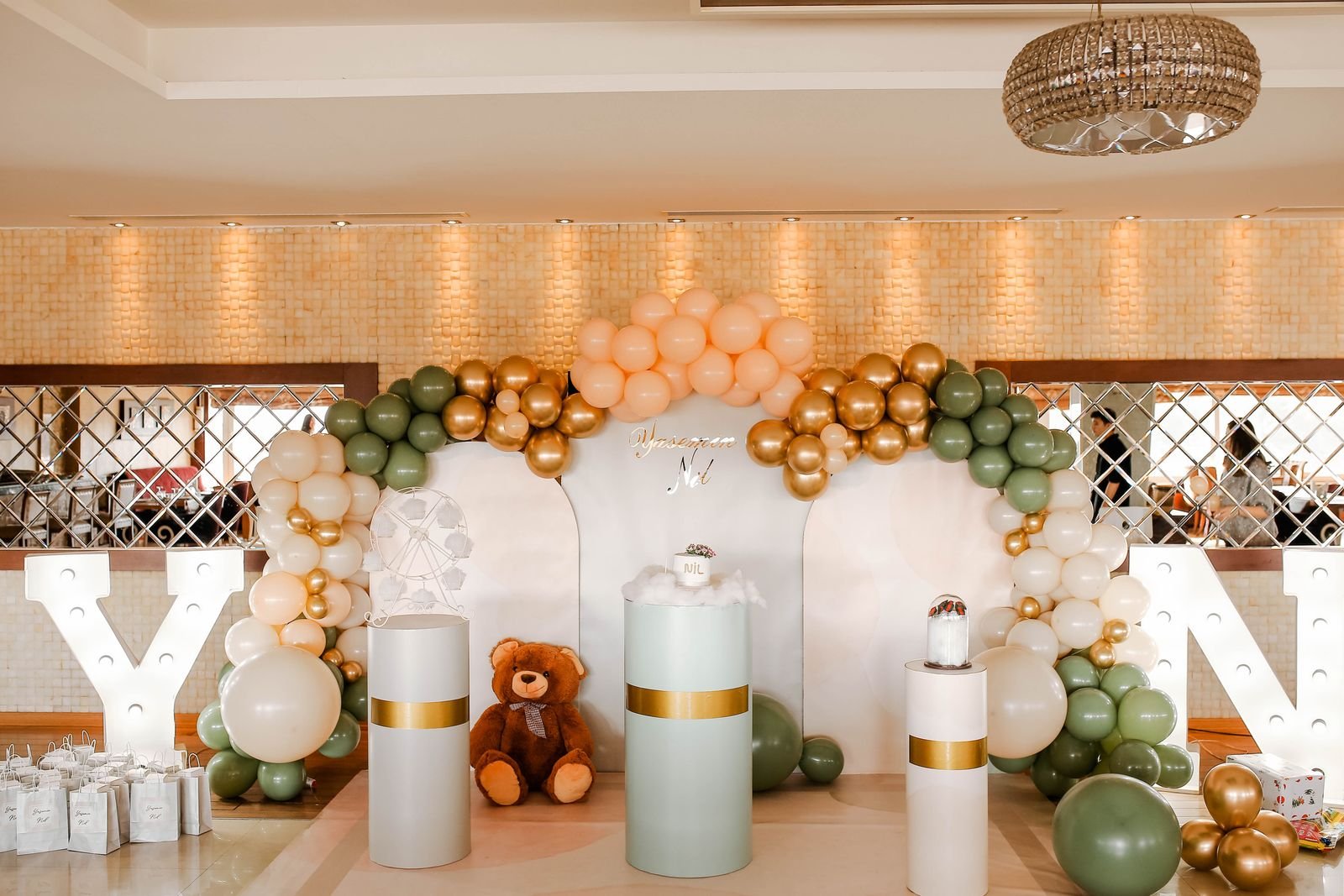 Balloons and a teddy bear in an indoor birthday setup.