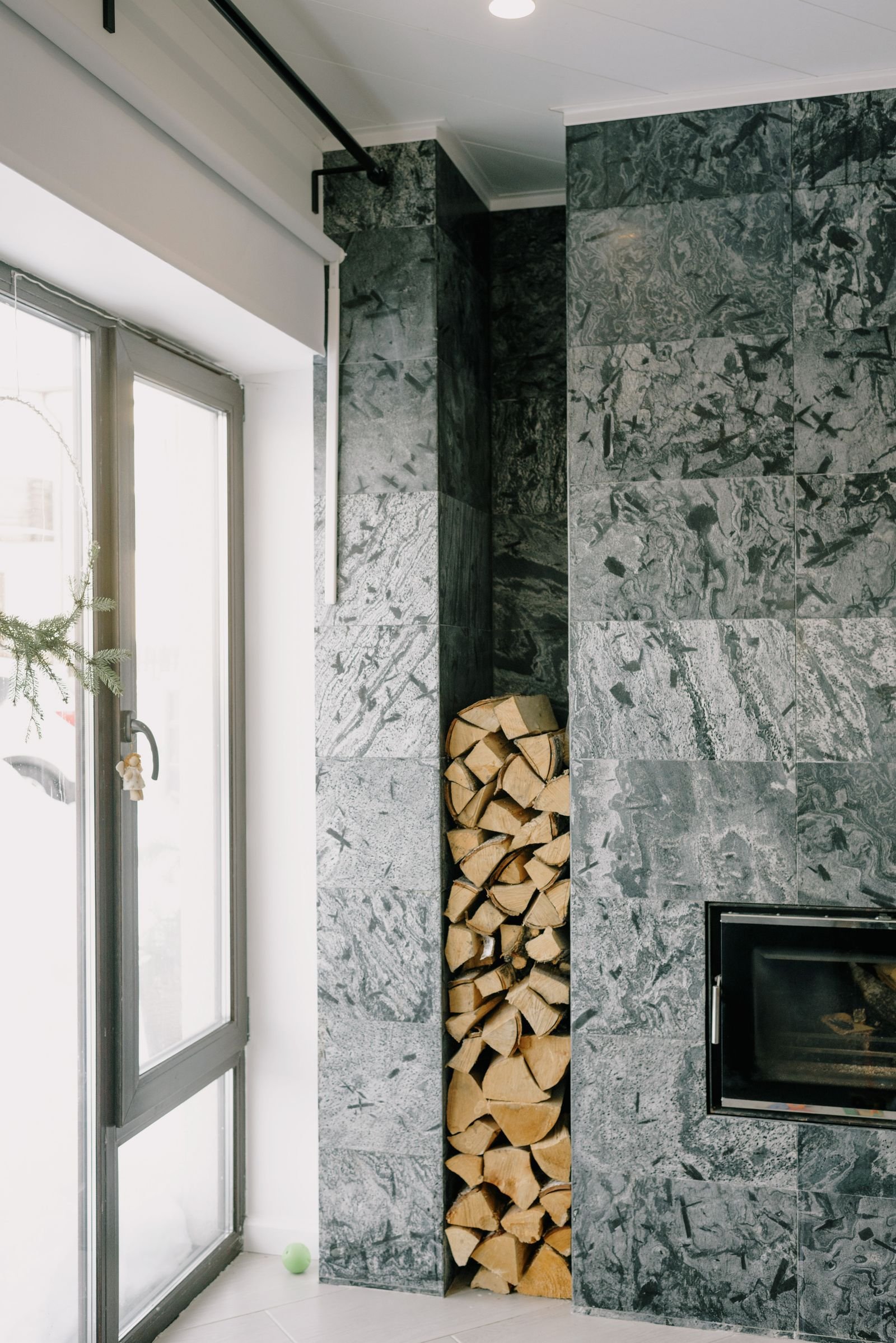 Cozy modern living room with a sleek fireplace and a stacked woodpile.
