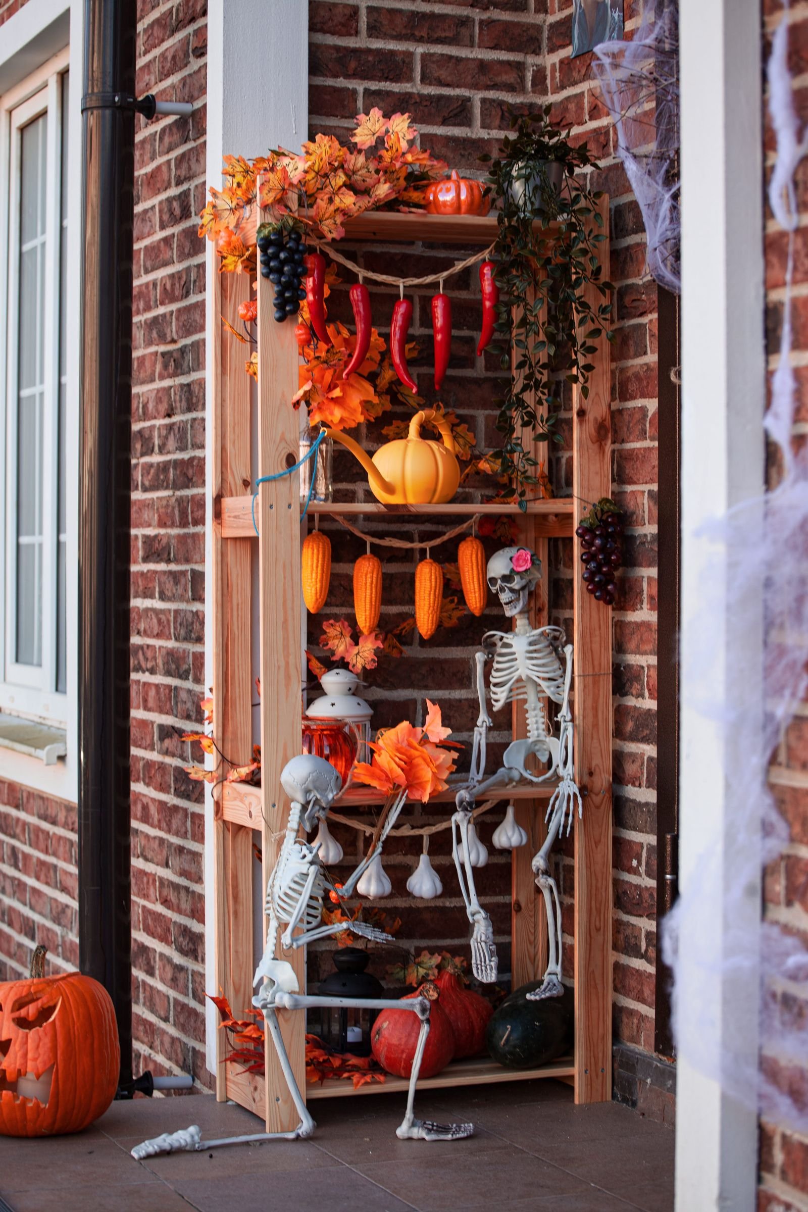 Shelf decorated for Halloween with skeletons, pumpkins and autumn leaves