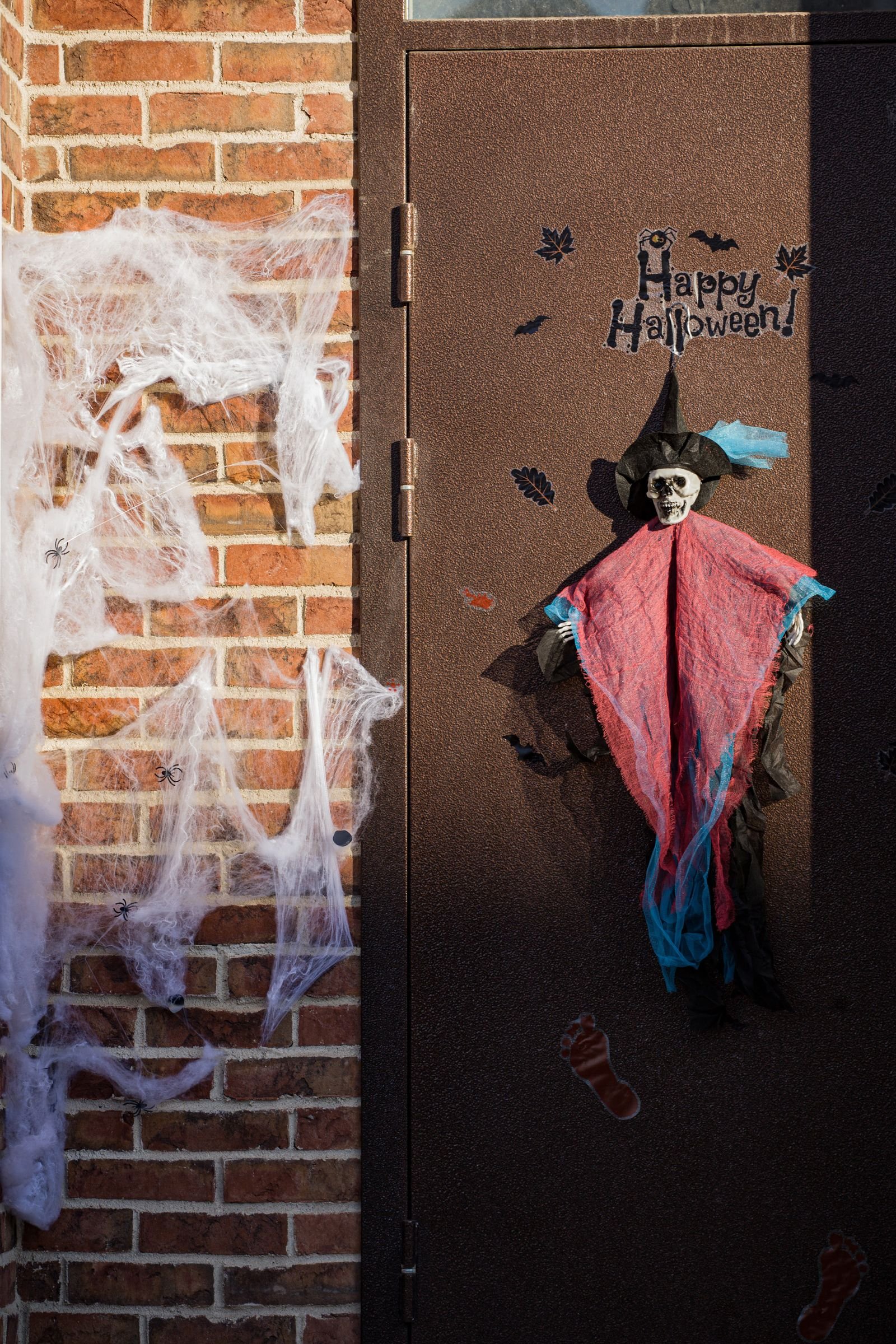 Hanging skeleton witch decoration and cobwebs on a front door