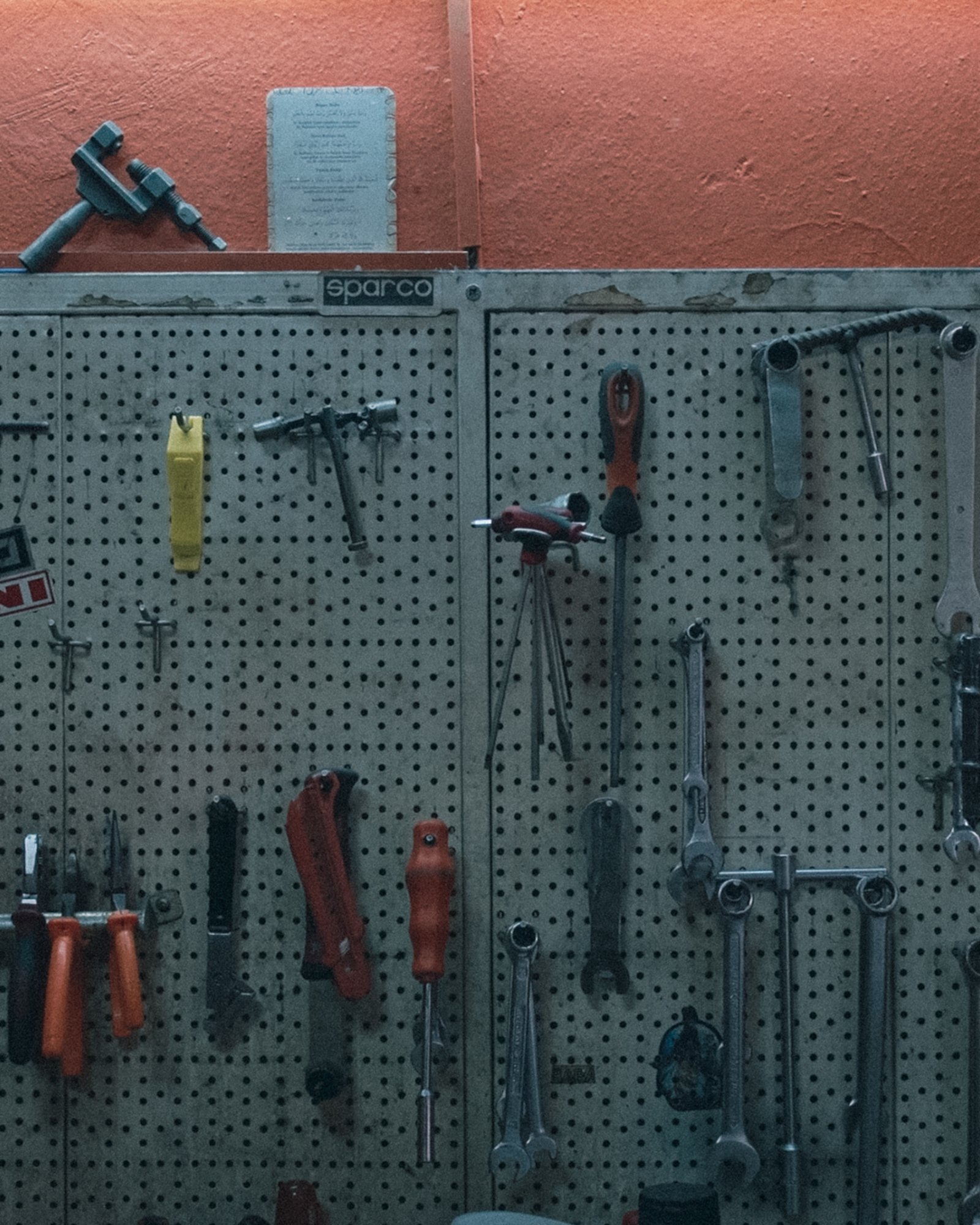 Hand tools hung neatly on a pegboard wall in a workshop.