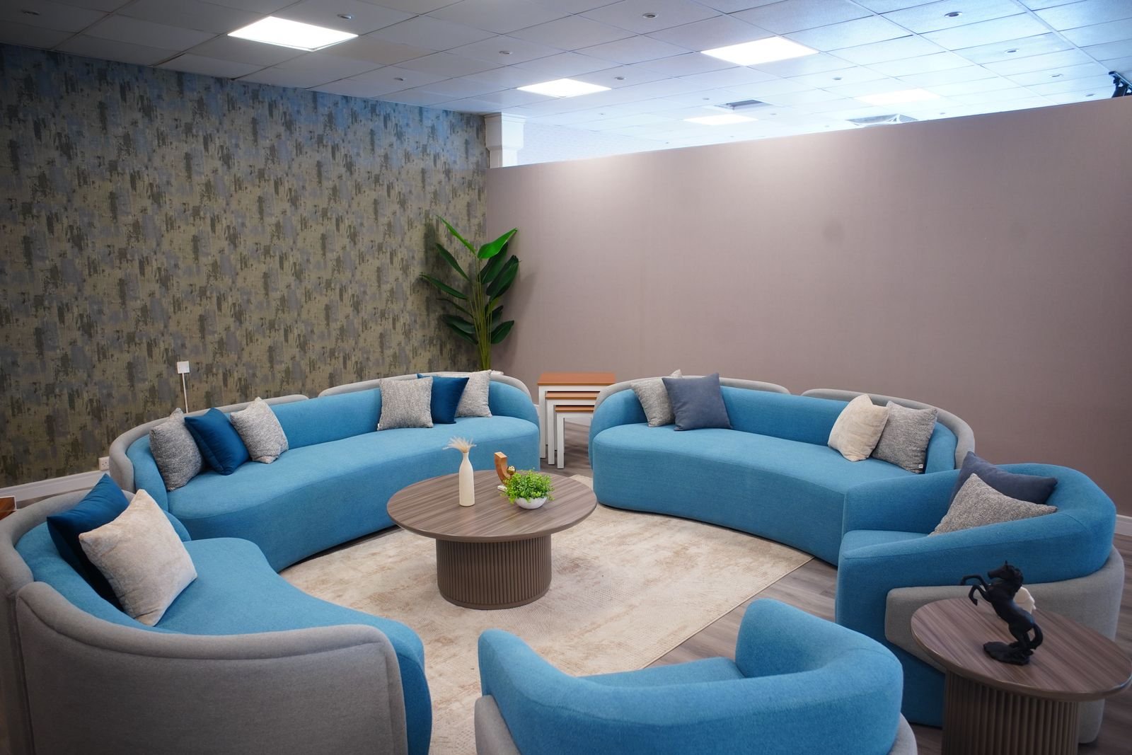 Modern living room with blue sofas and cozy decor.