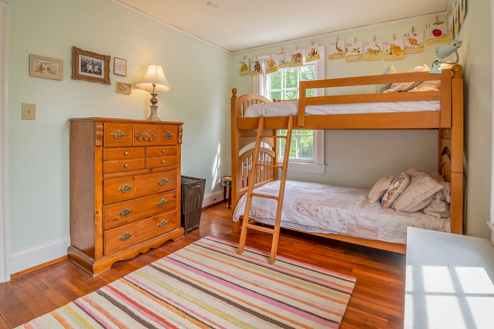Children's bedroom with a wooden bunk bed and colorful decor.