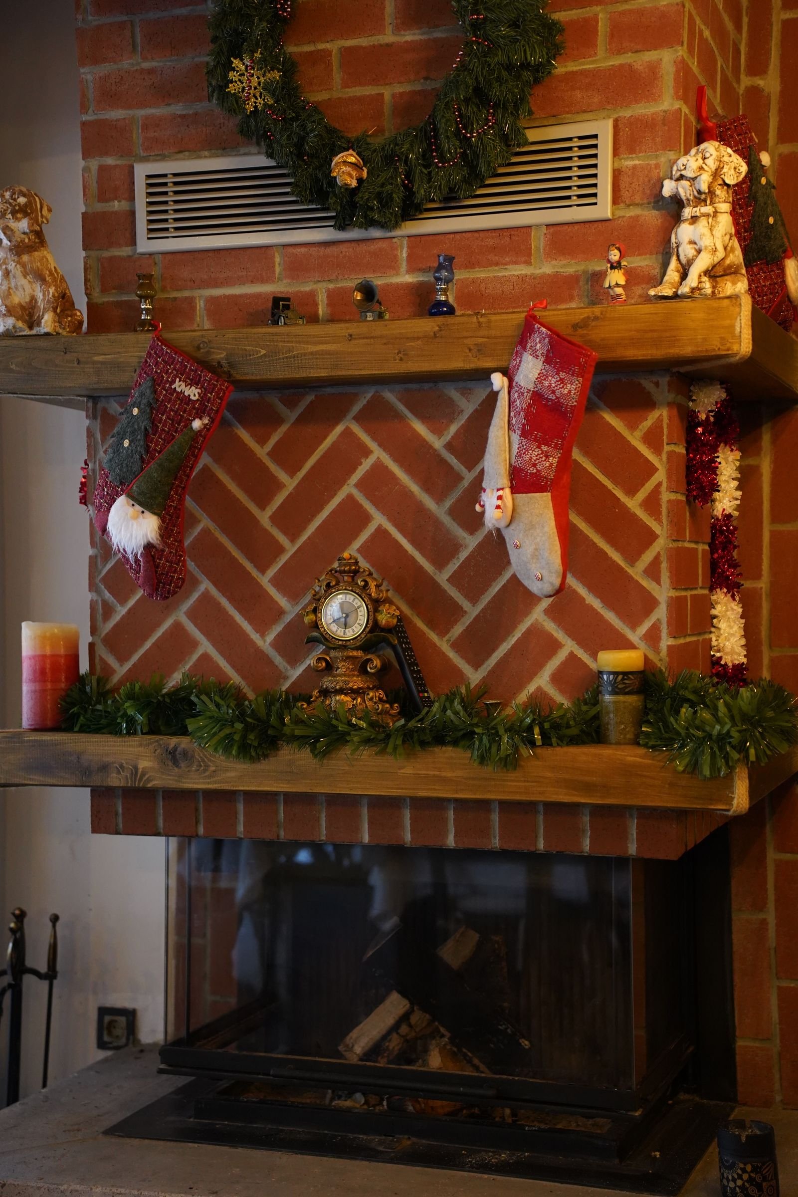 Fireplace with festive Christmas decorations and stockings in a warm room.