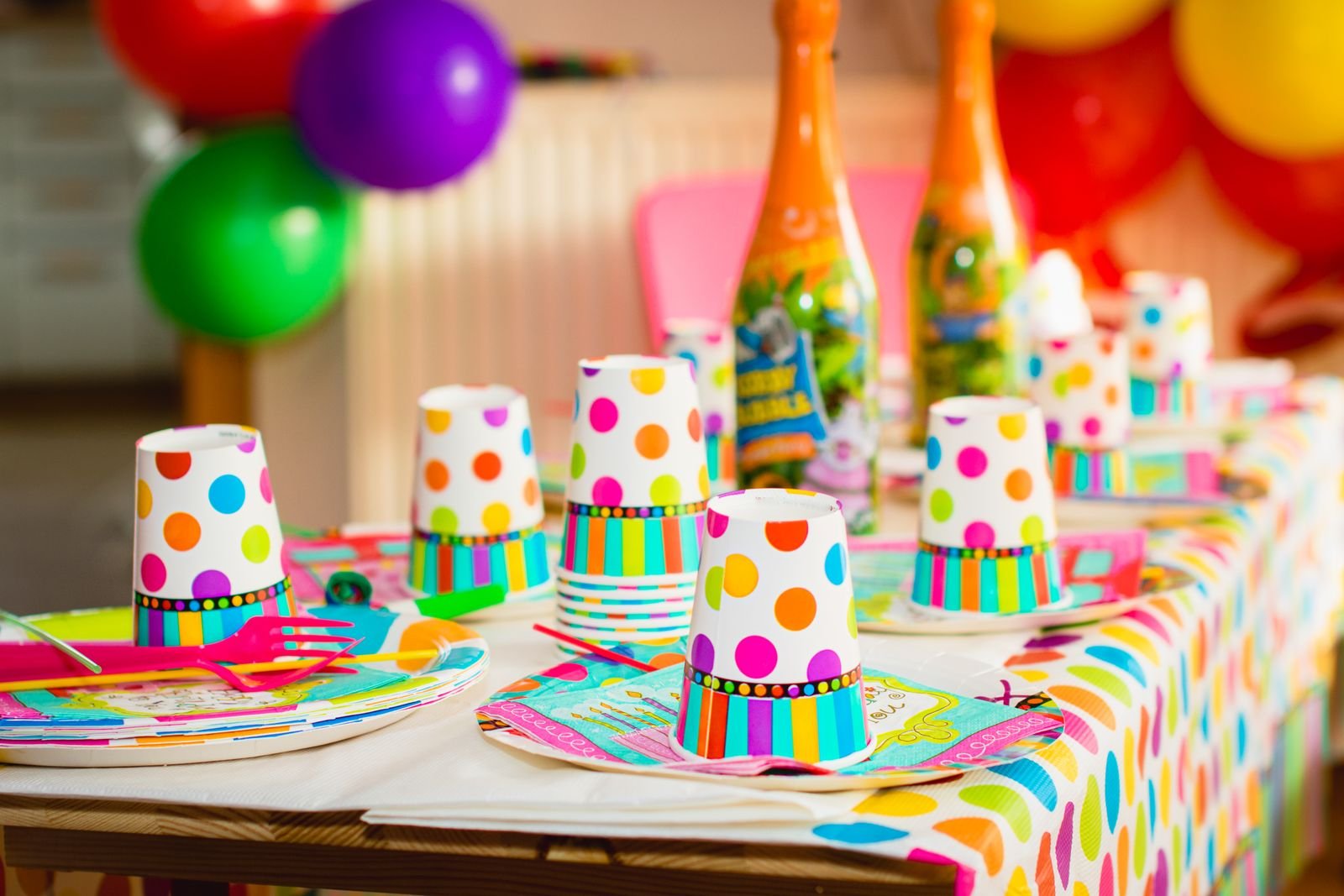 Party table with polka-dot cups, plates and balloons.