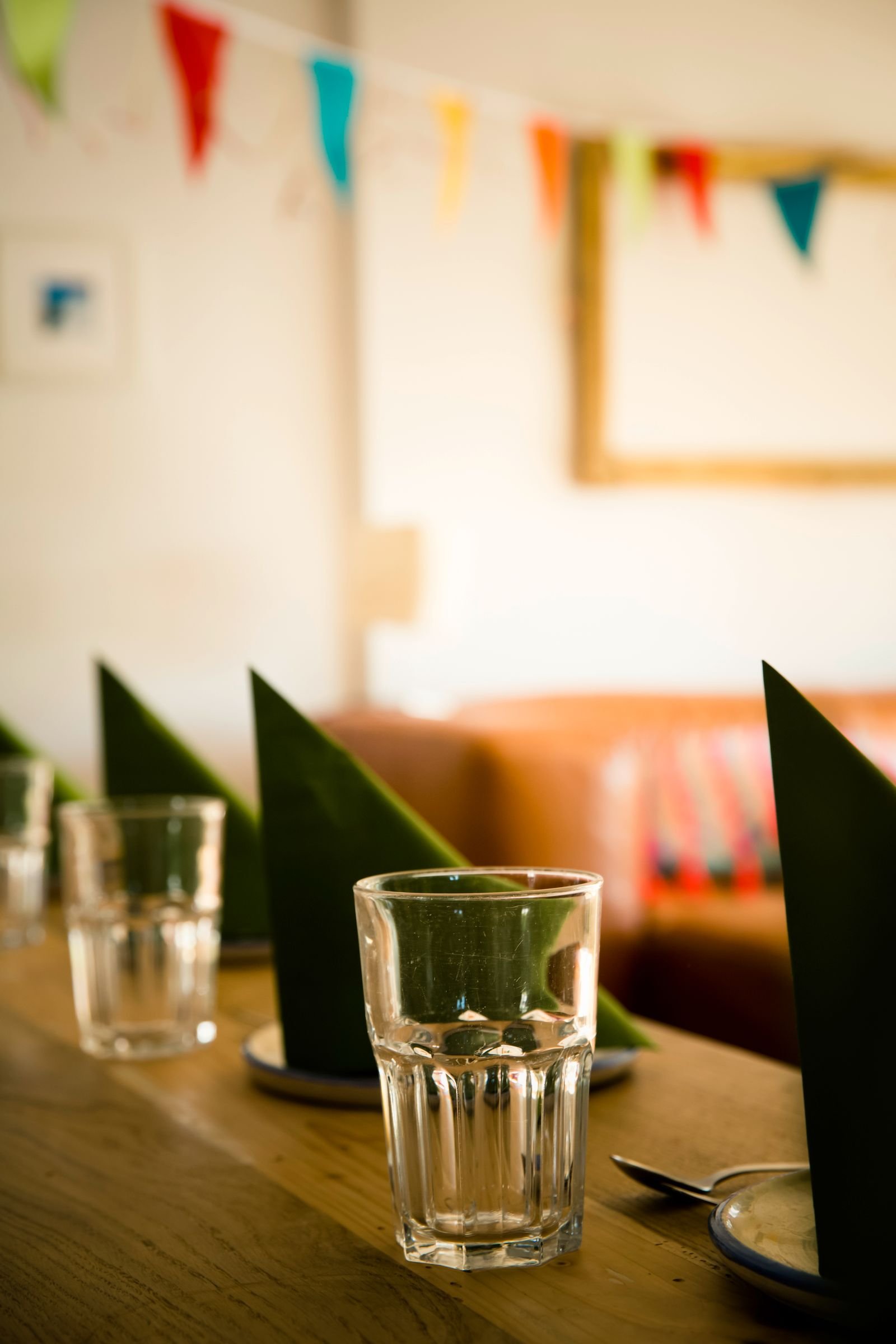 Festive table setting with glasses, napkins and colorful bunting.