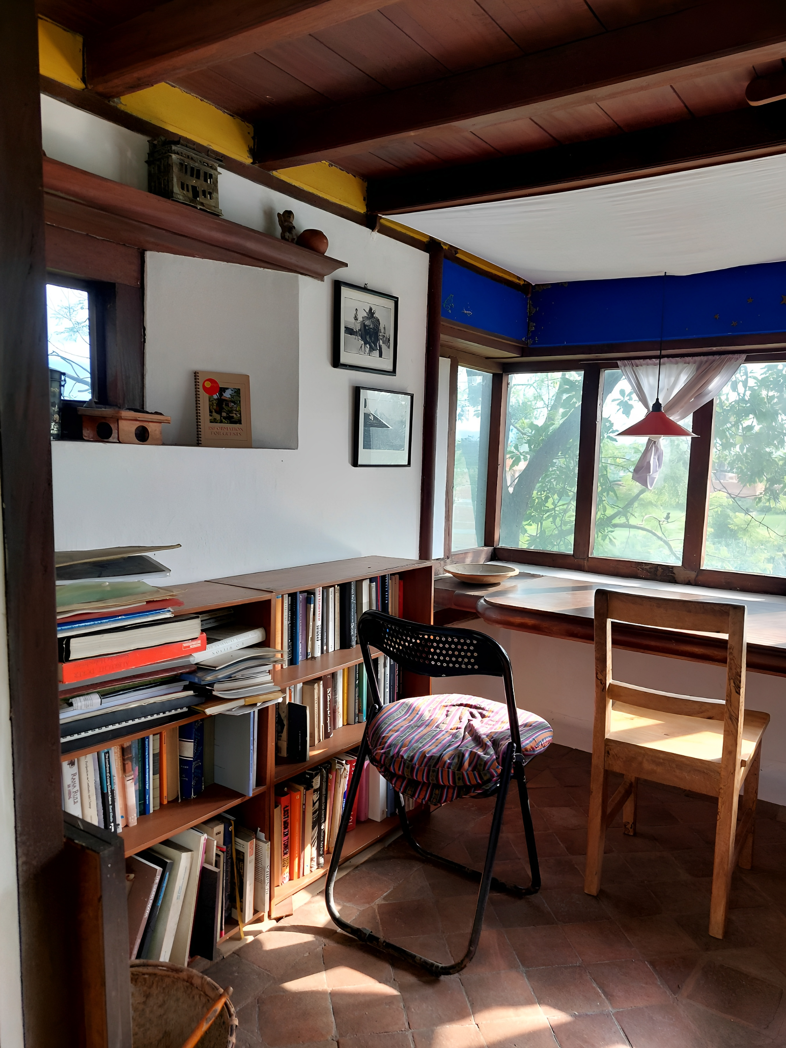 Bright home office with bookshelves, chairs and large windows.