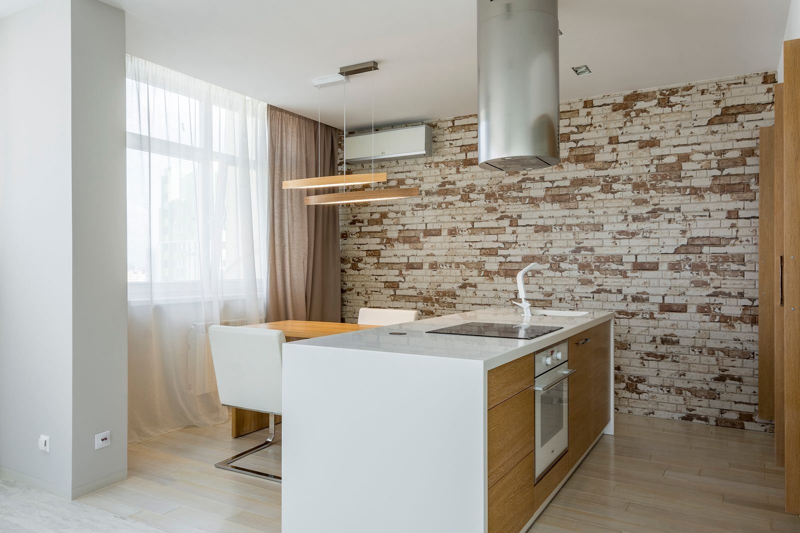 Open-plan kitchen and dining area with a brick accent wall.