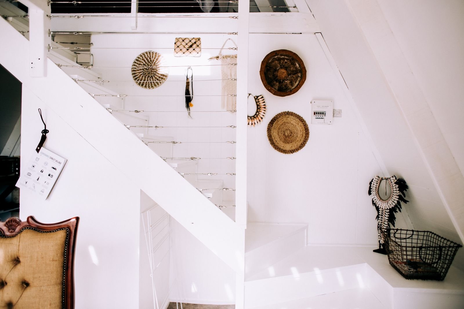 White staircase beside a wall with framed art in a minimalist home.