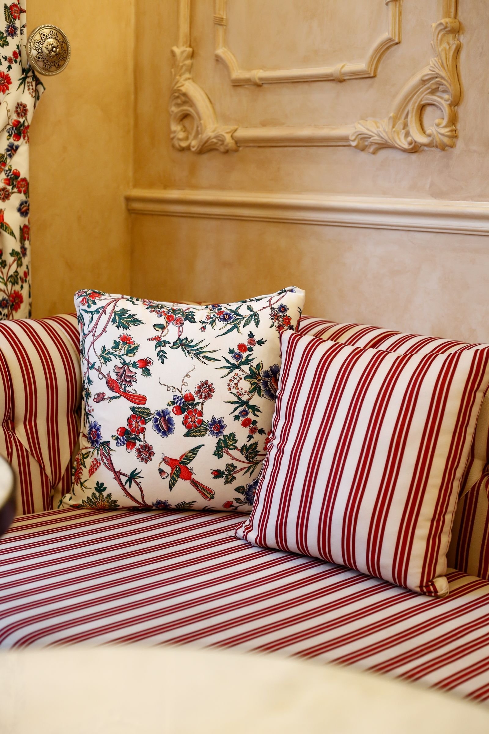 Floral and striped cushions on a classic couch in a living room.