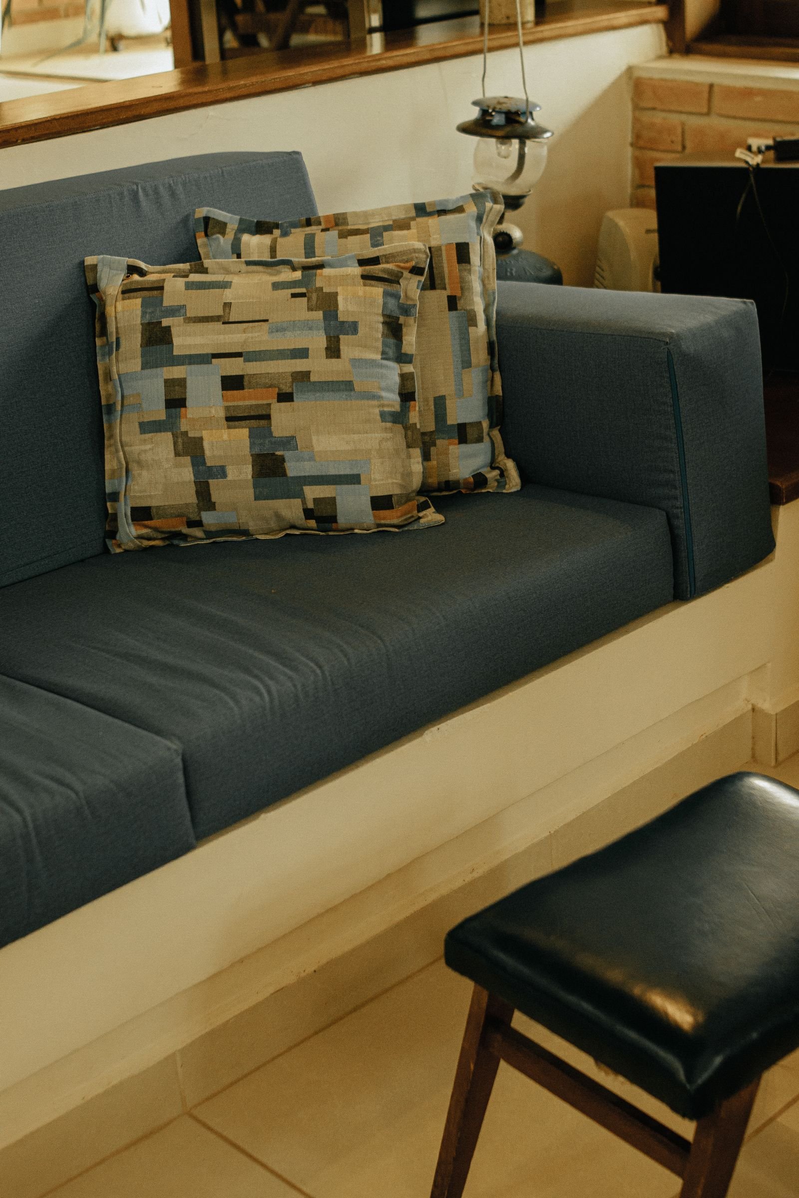 Blue sofa with abstract patterned cushions in a cozy room.