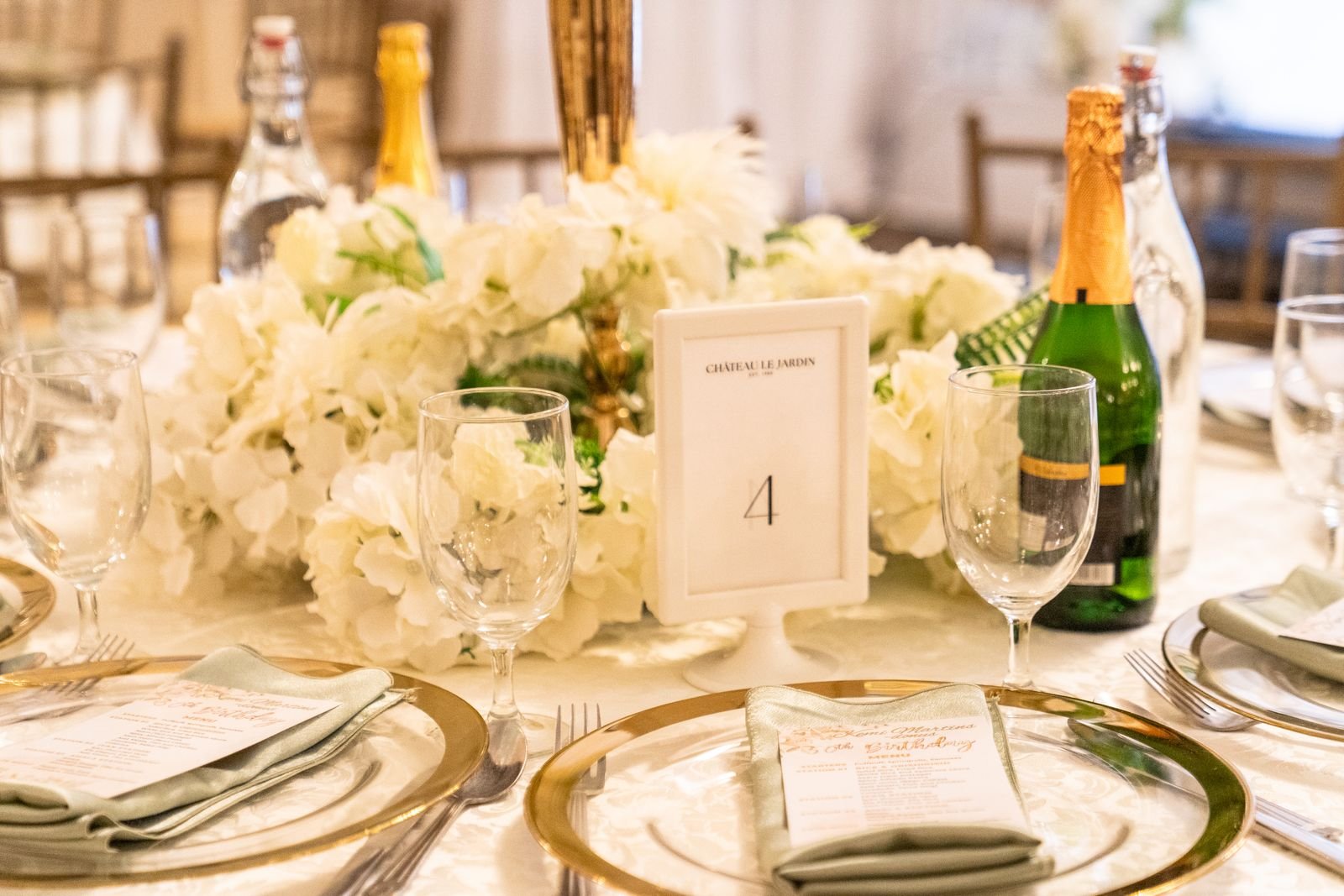 Table set for a celebration with a floral centerpiece and champagne.