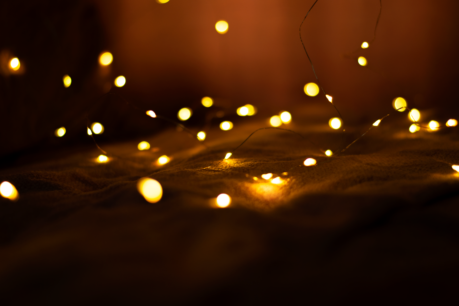 Warm yellow string lights glowing softly in a dark room.