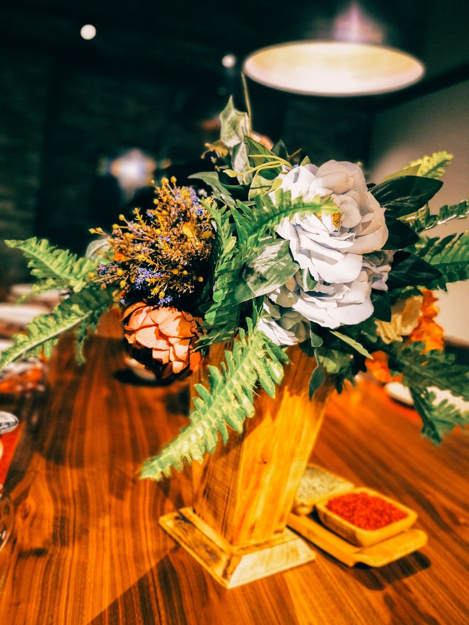 Flower arrangement in a wooden vase on a table.