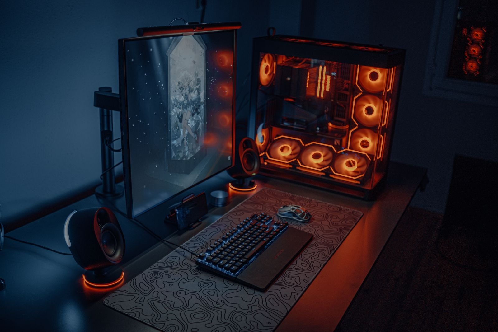 Gaming desk with RGB lighting, a large monitor and a glowing PC.