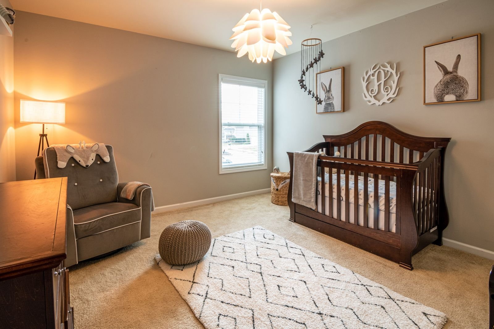 Baby room with a wooden crib, an armchair and soft decor.