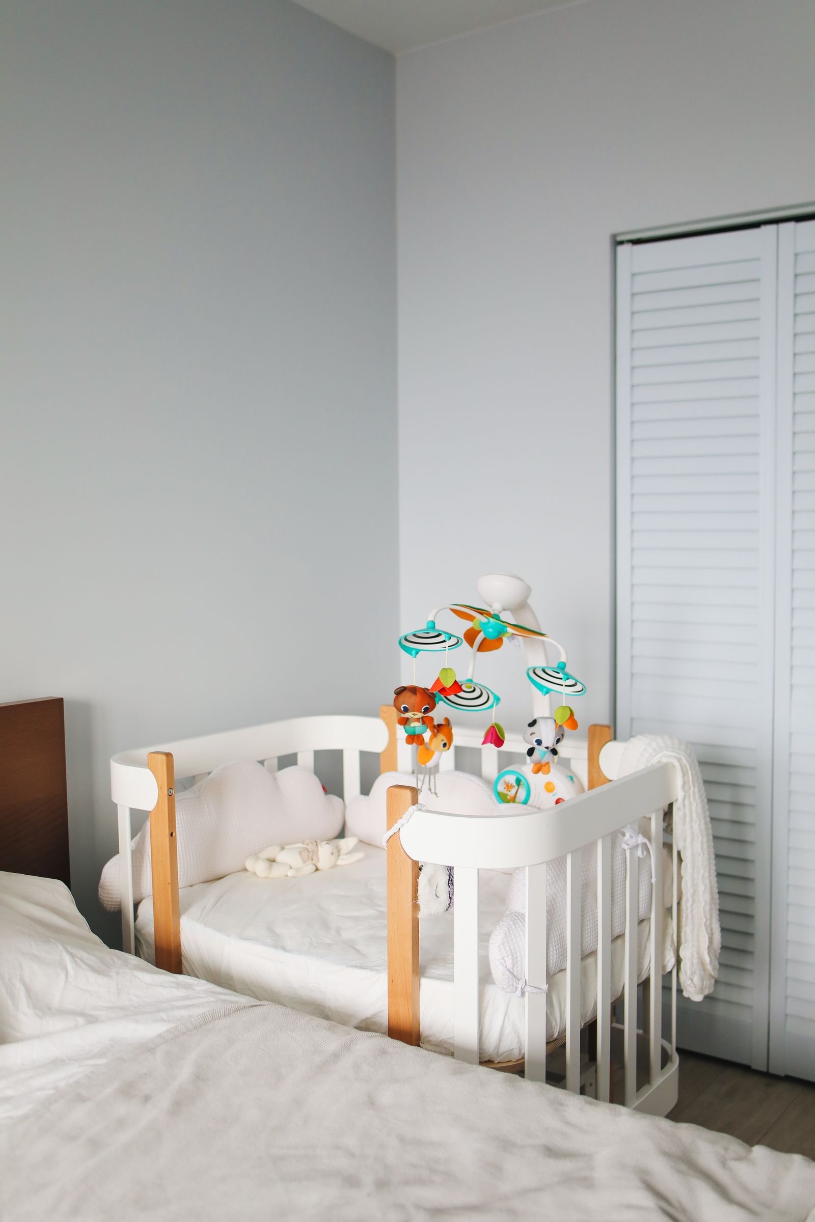 White wooden crib in a bright bedroom.