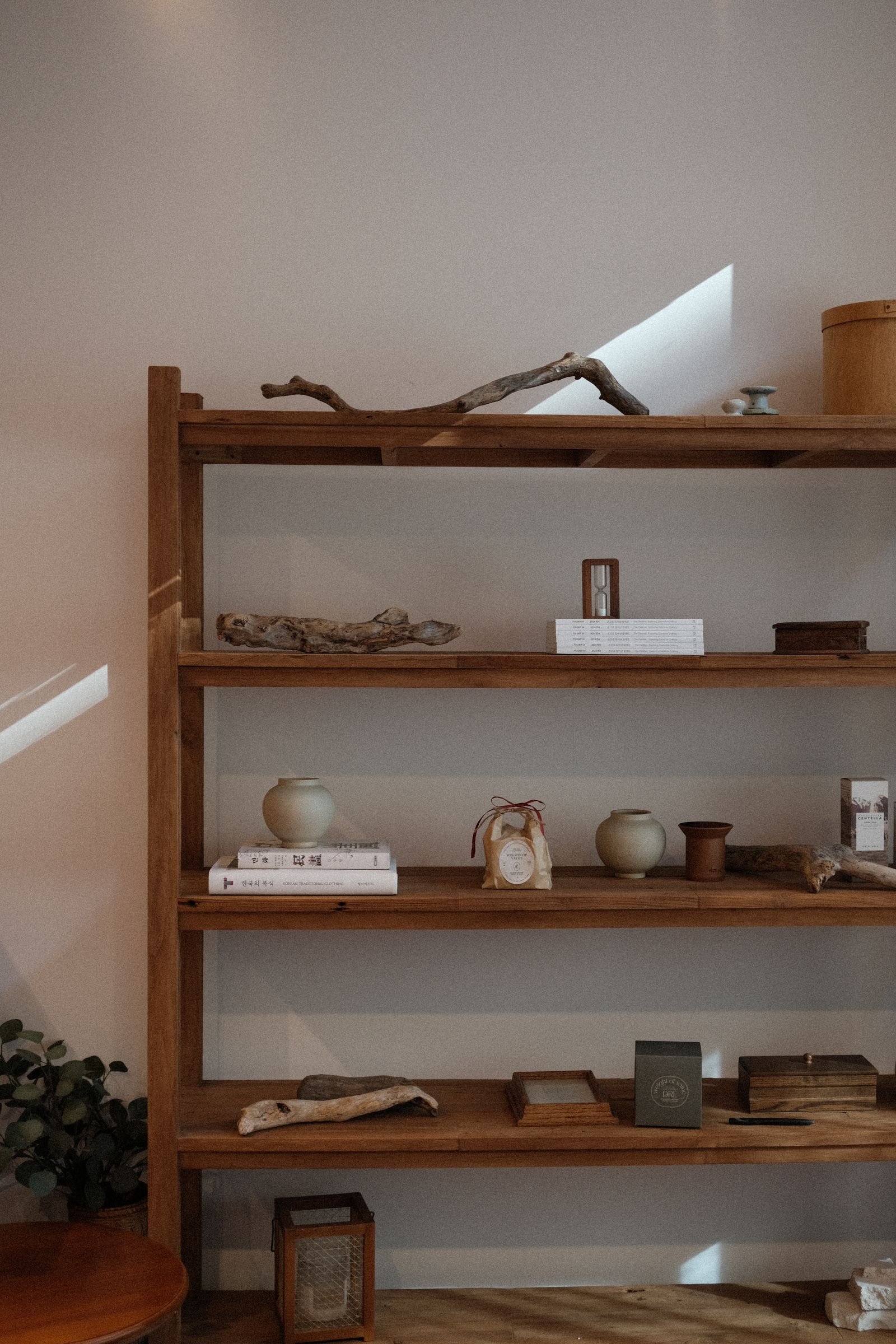 Wooden bookshelf with decorative objects in a warm interior.