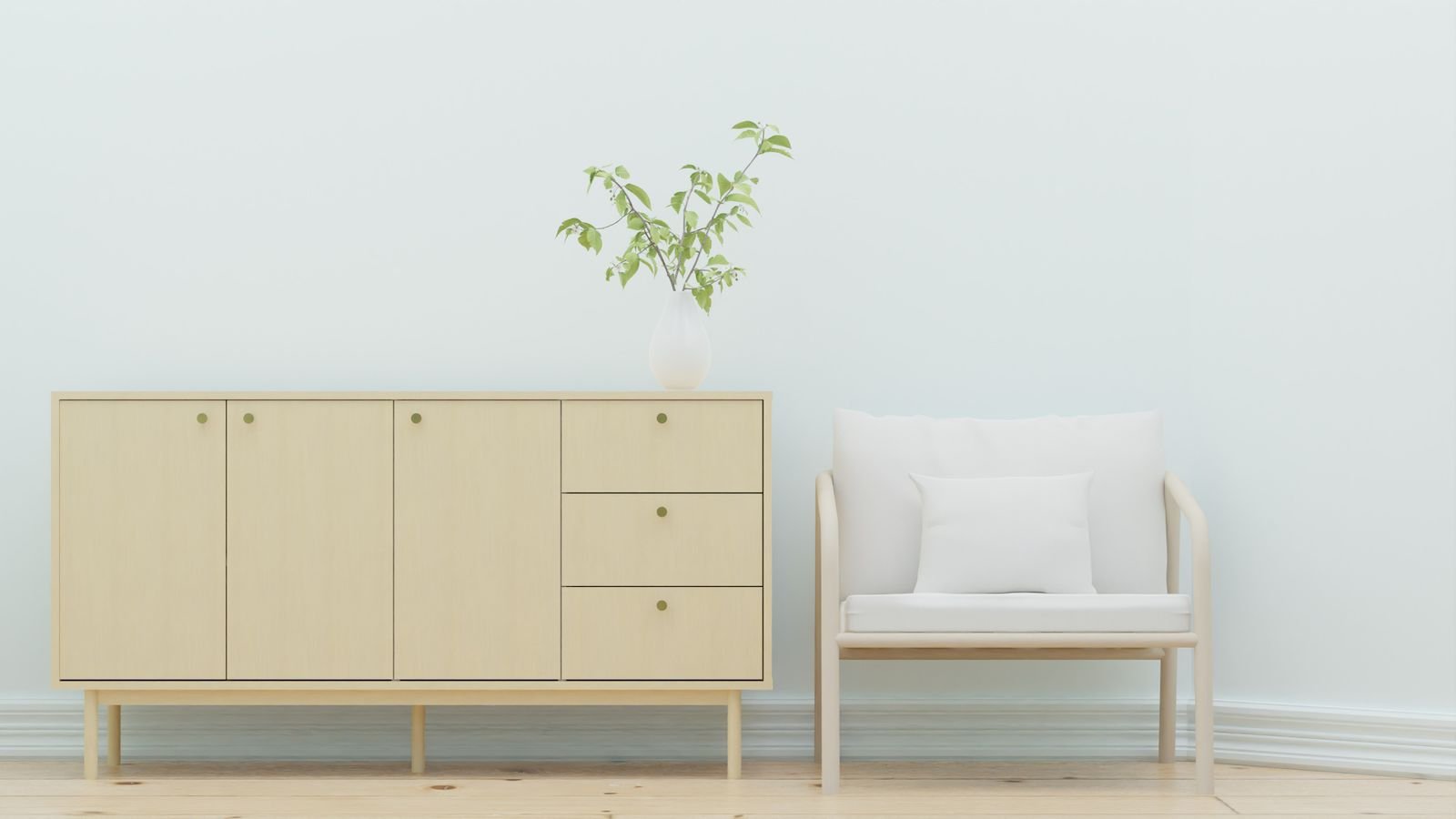 Wooden sideboard beside a white armchair and green plant.