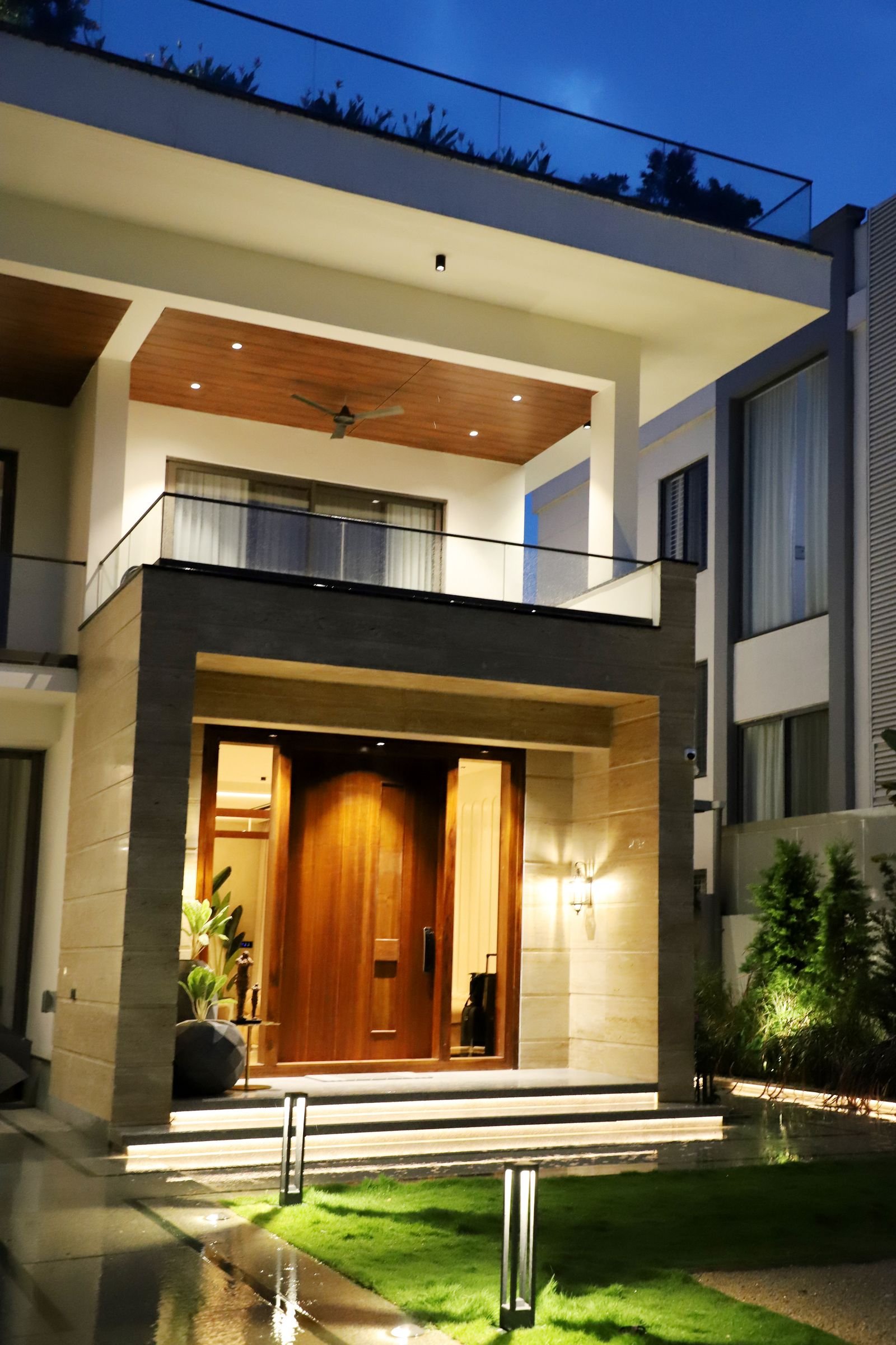Modern home entrance lit with warm lights at night.
