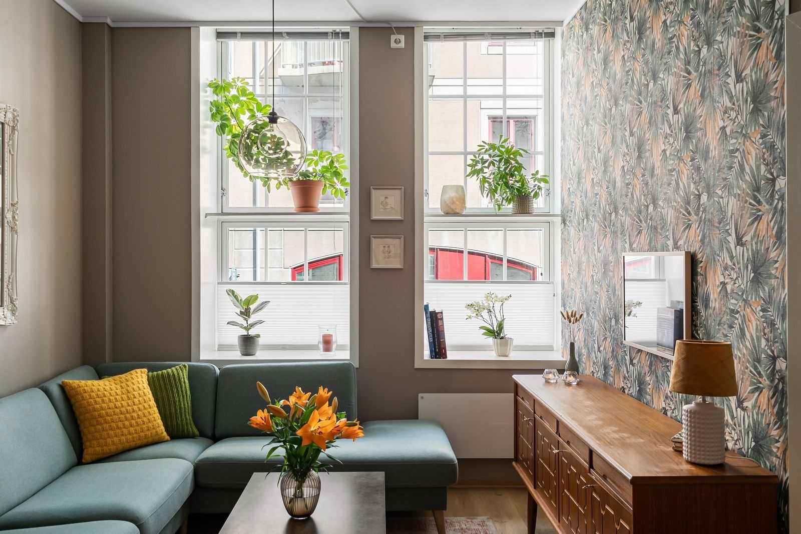 Living room with plants, soft furnishings and plenty of natural light.