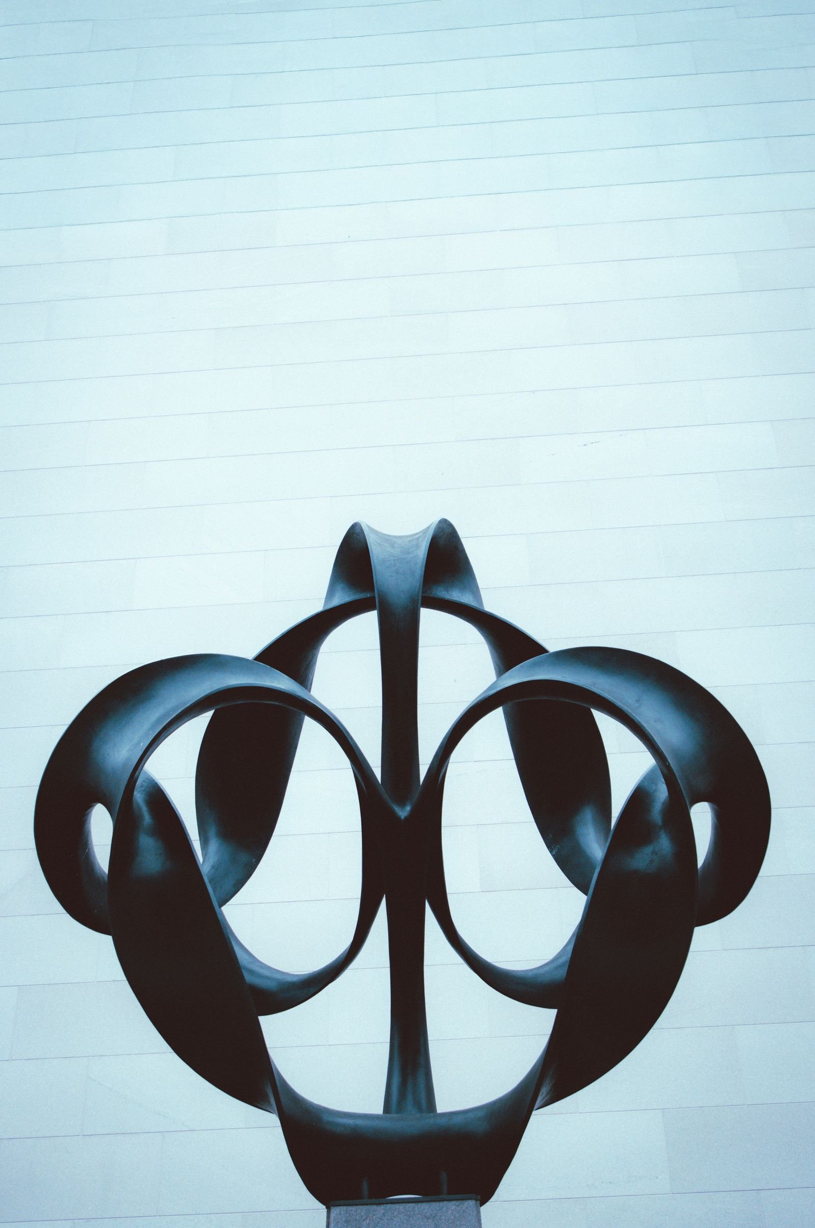 Abstract black sculpture against a minimalist wall.