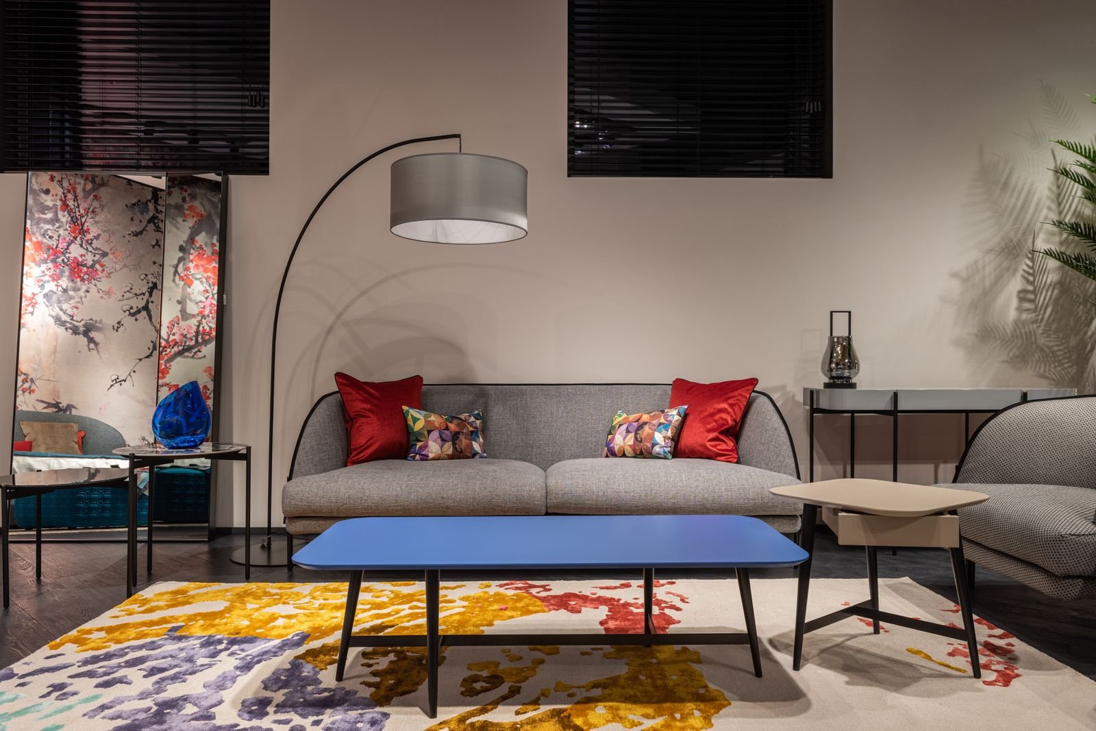 Sofa with colorful cushions, an armchair and a table in a spacious living room.
