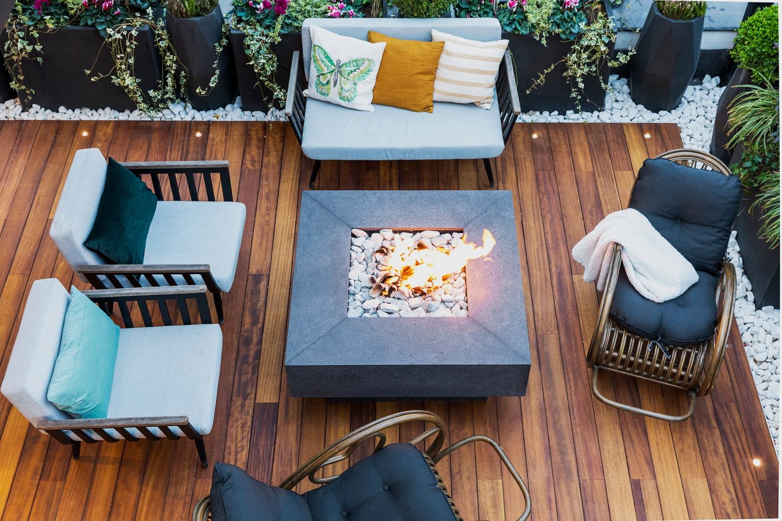 Modern patio seen from above with stylish seating around a central fire pit.