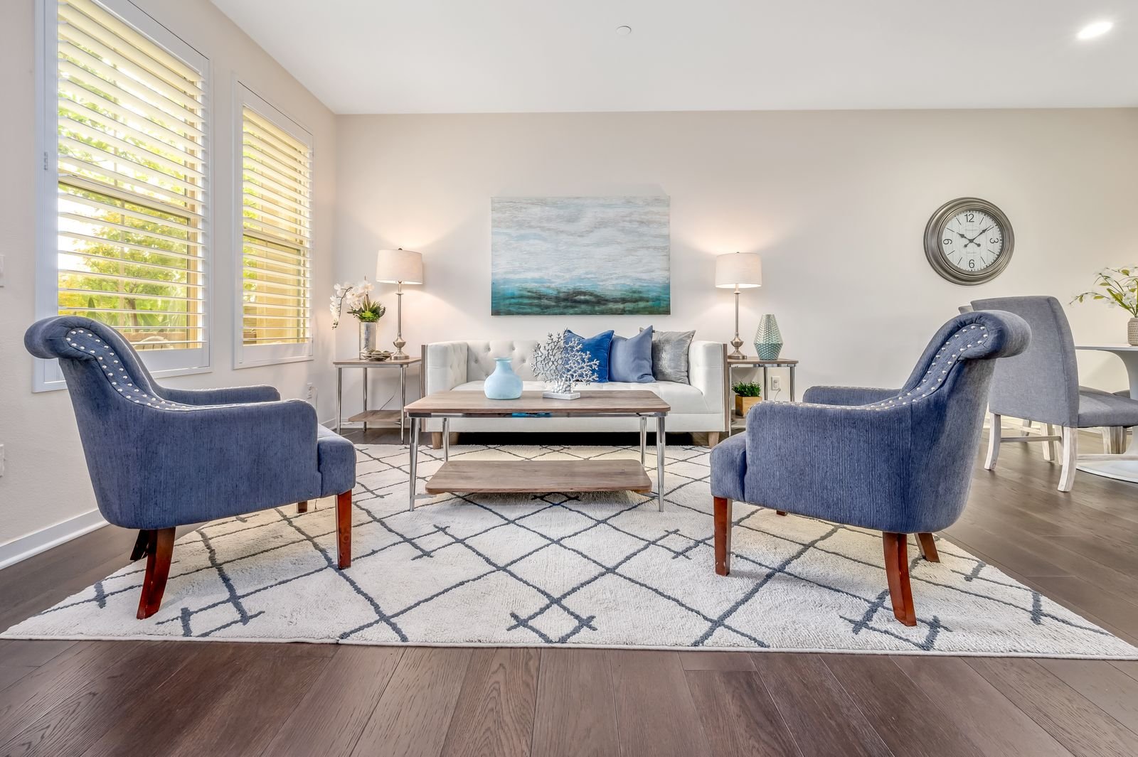 Clean, bright living room with blue chairs and simple decor.