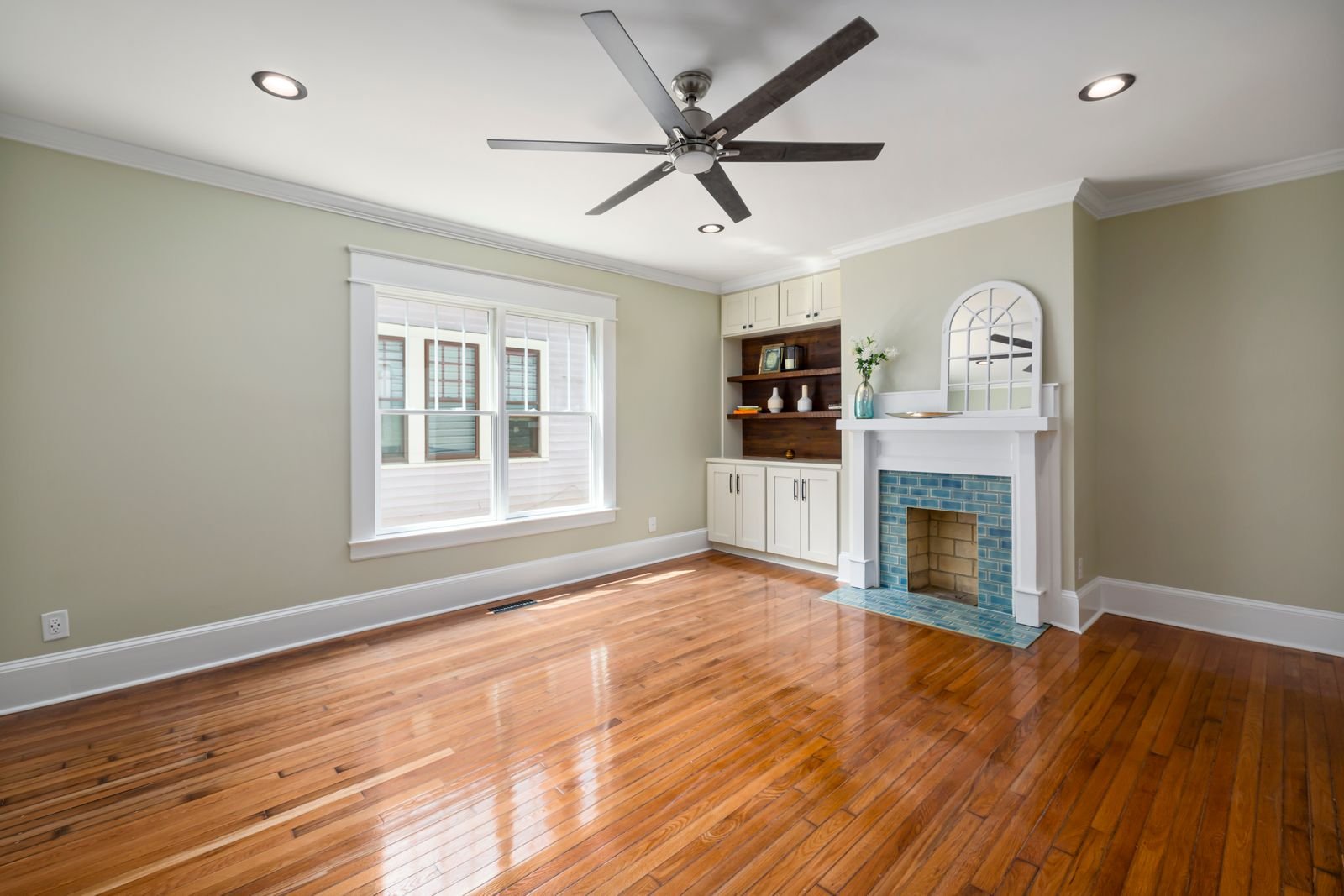 Empty living room with hardwood floors and a fireplace.